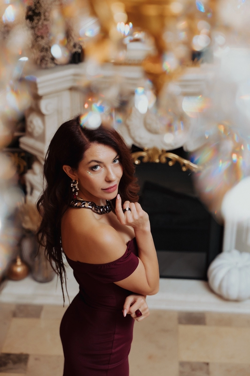 Женщина надувает жёлтый шар на фоне неоновой вывески Party