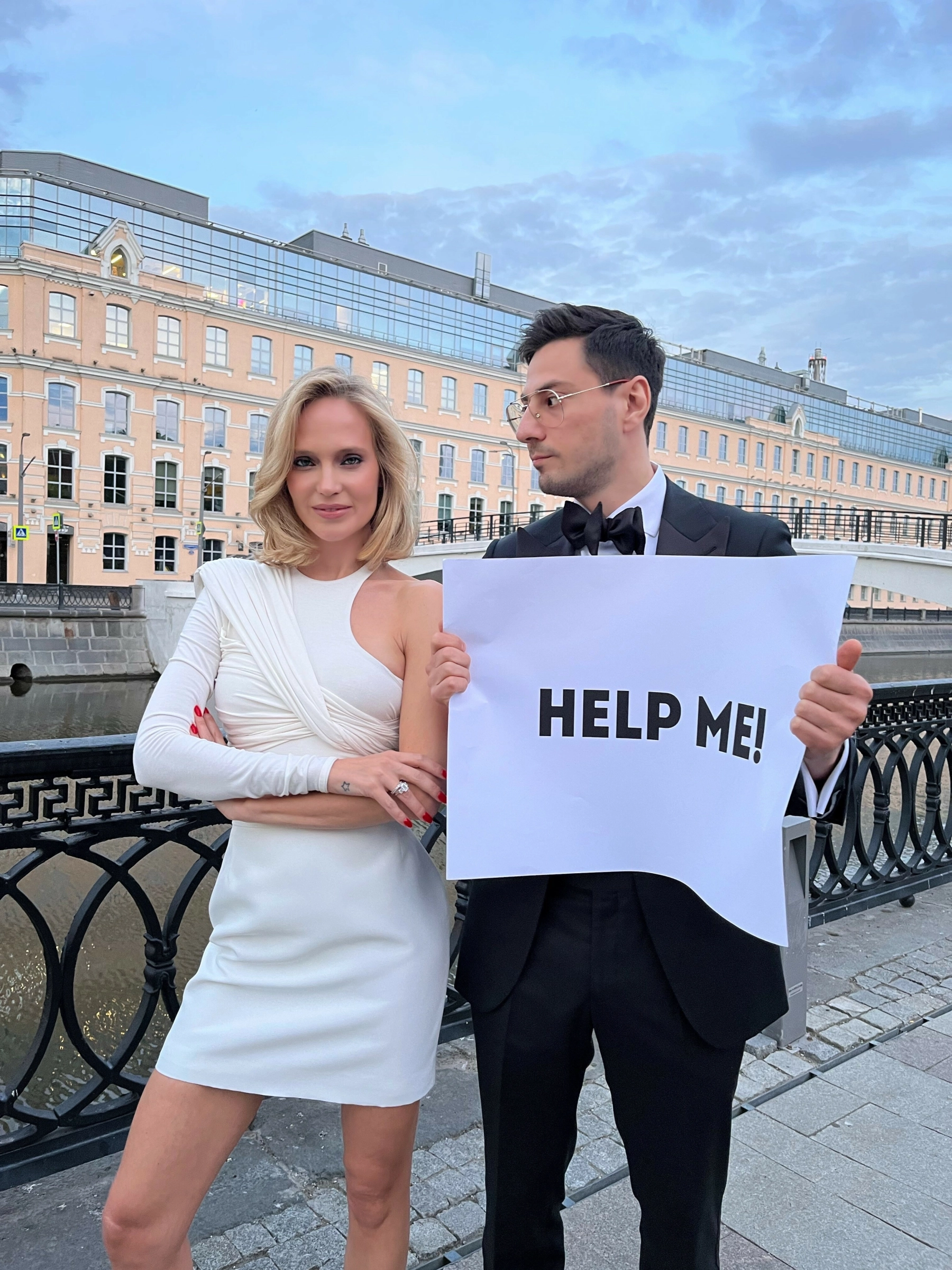 мужчина и женщина держат плакат на фоне набережной