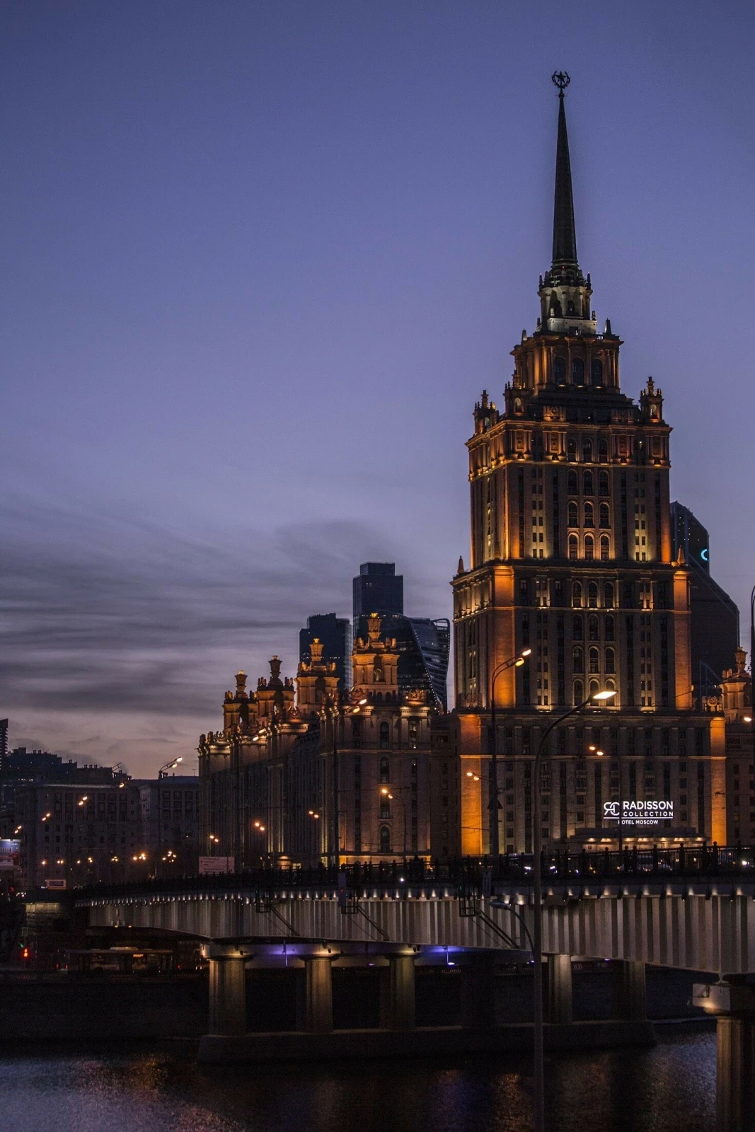 невеста улыбается на мосту на фоне сталинской высотки