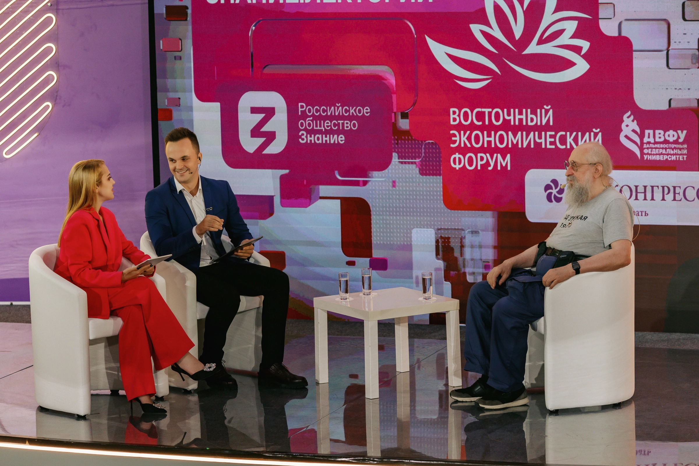 ведущий мероприятия на фоне неоновых граффити-лент на сцене