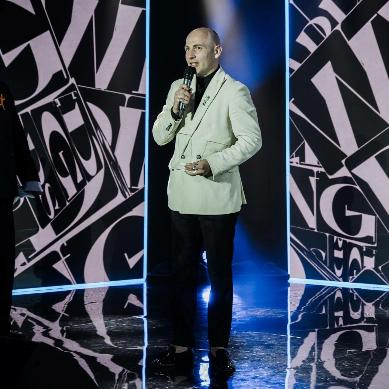 дуэт ведущих в фиолетовых нарядах на праздничной новогодней сцене