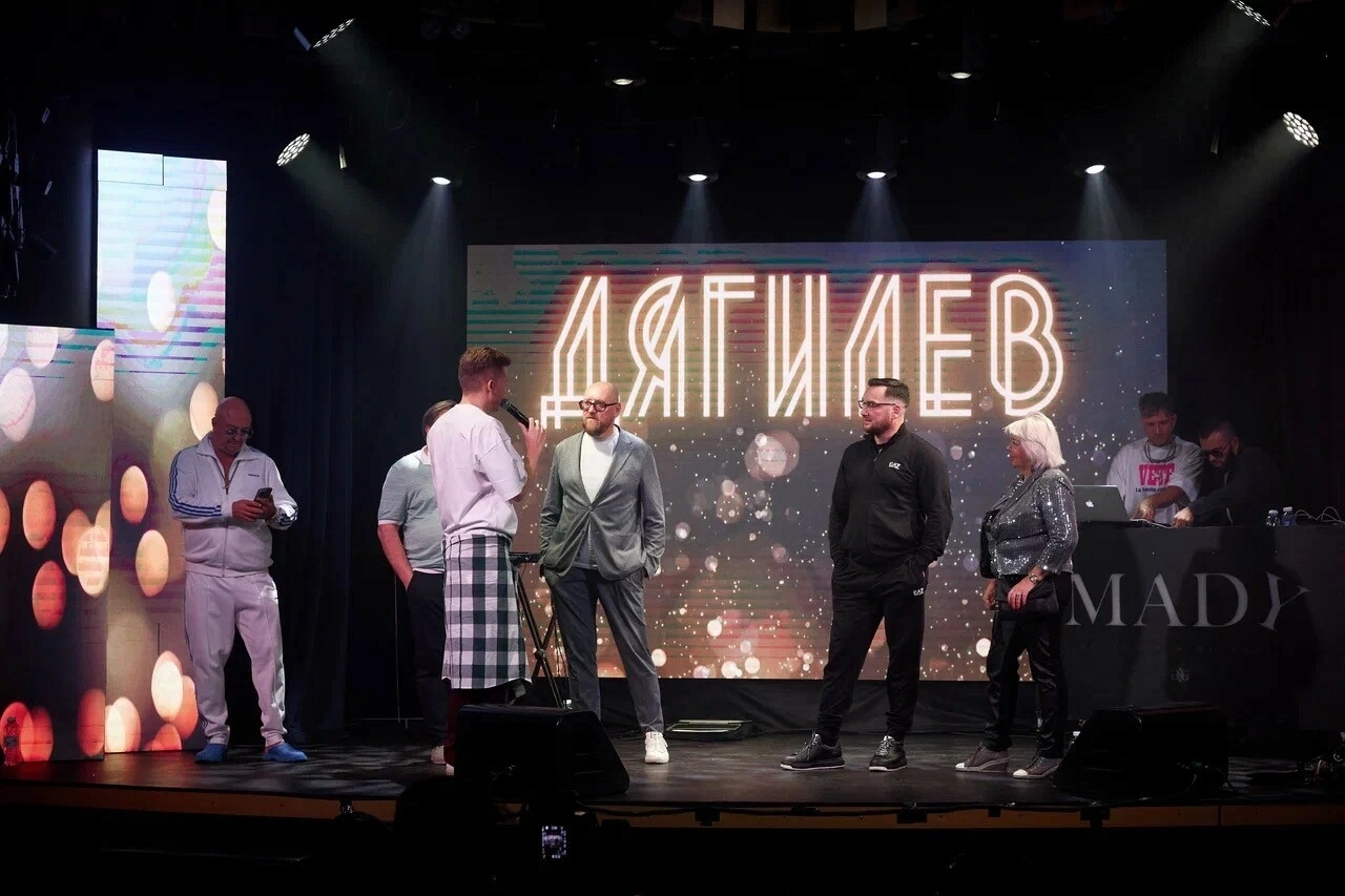 ведущий на сцене творческой премии с группой гостей