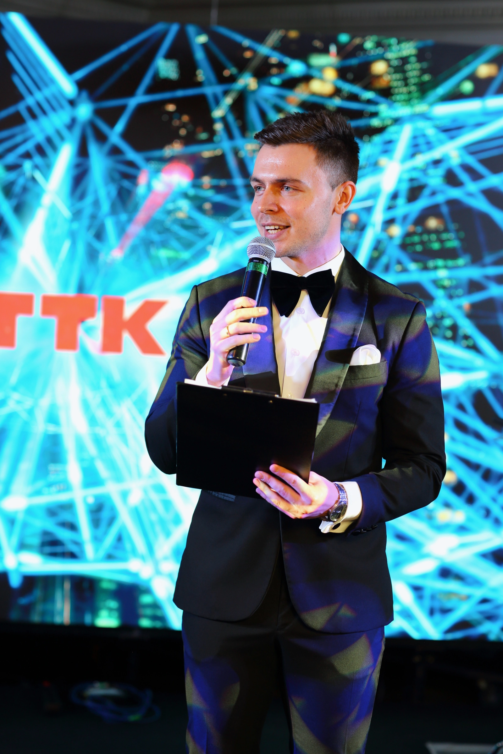 ведущий с папкой выступает на форуме телеком компании