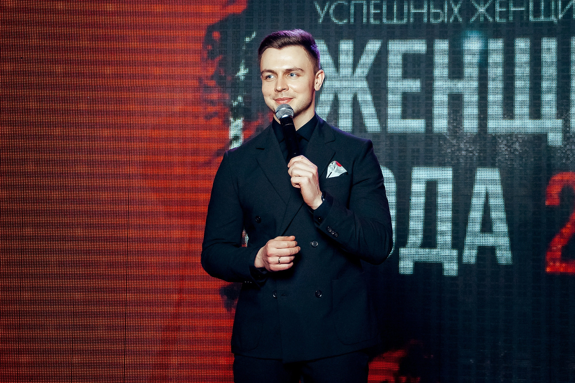 ведущий с микрофоном на церемонии премии для женщин