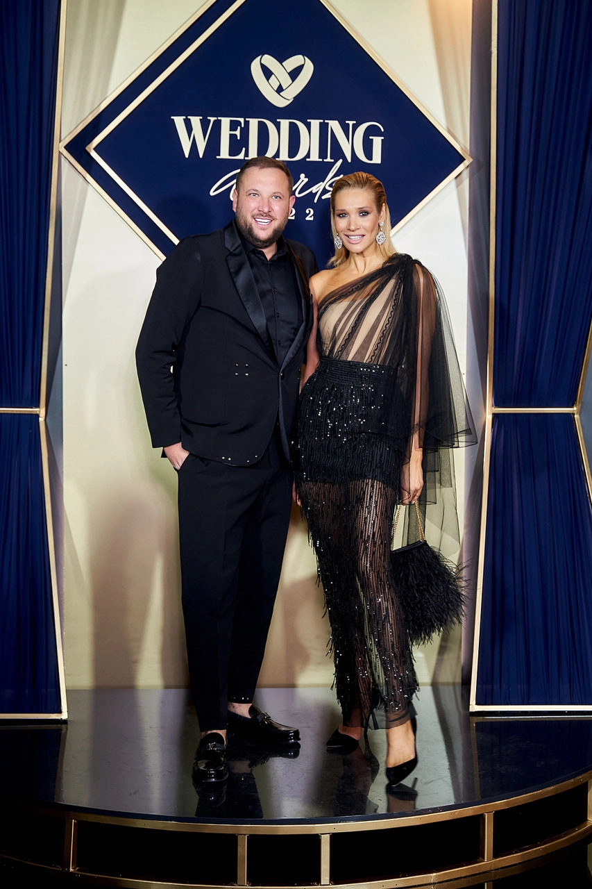 ведущая в чёрном платье с бахромой на сцене премии Wedding Awards