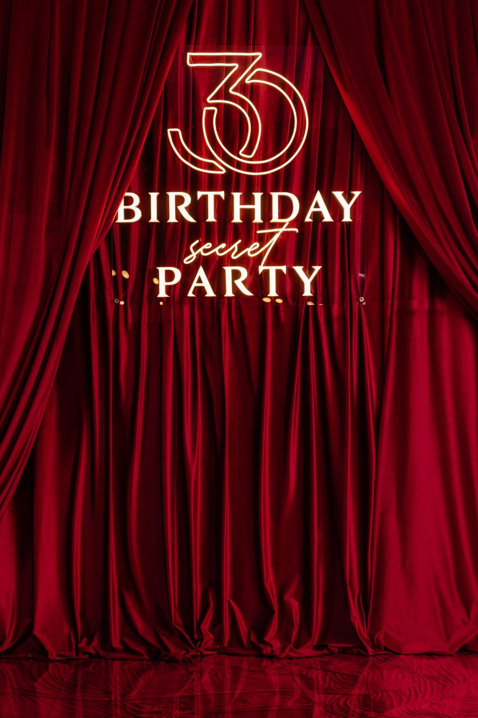 красный бархатный занавес с неоновой надписью birthday secret party