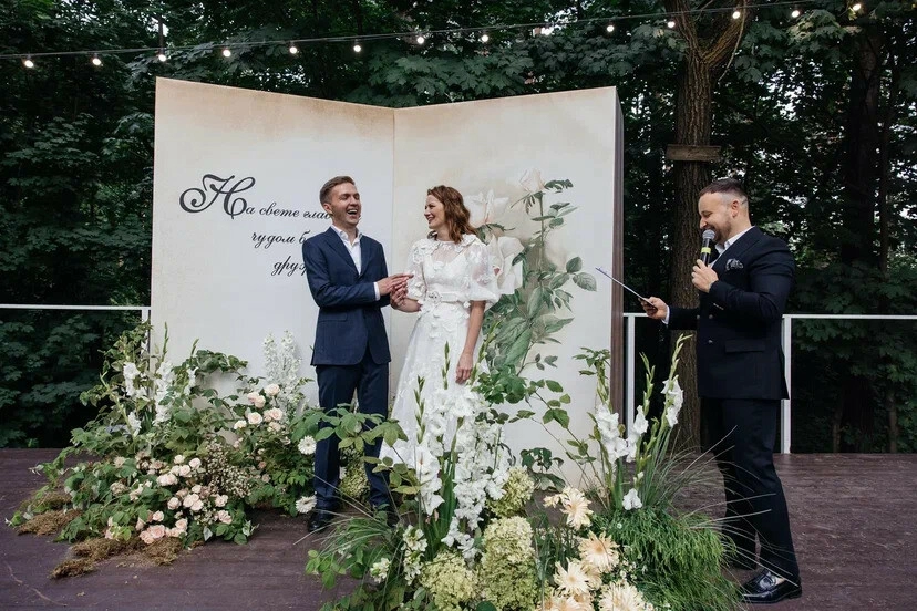 ведущий проводит выездную церемонию у цветочного декора в виде книги