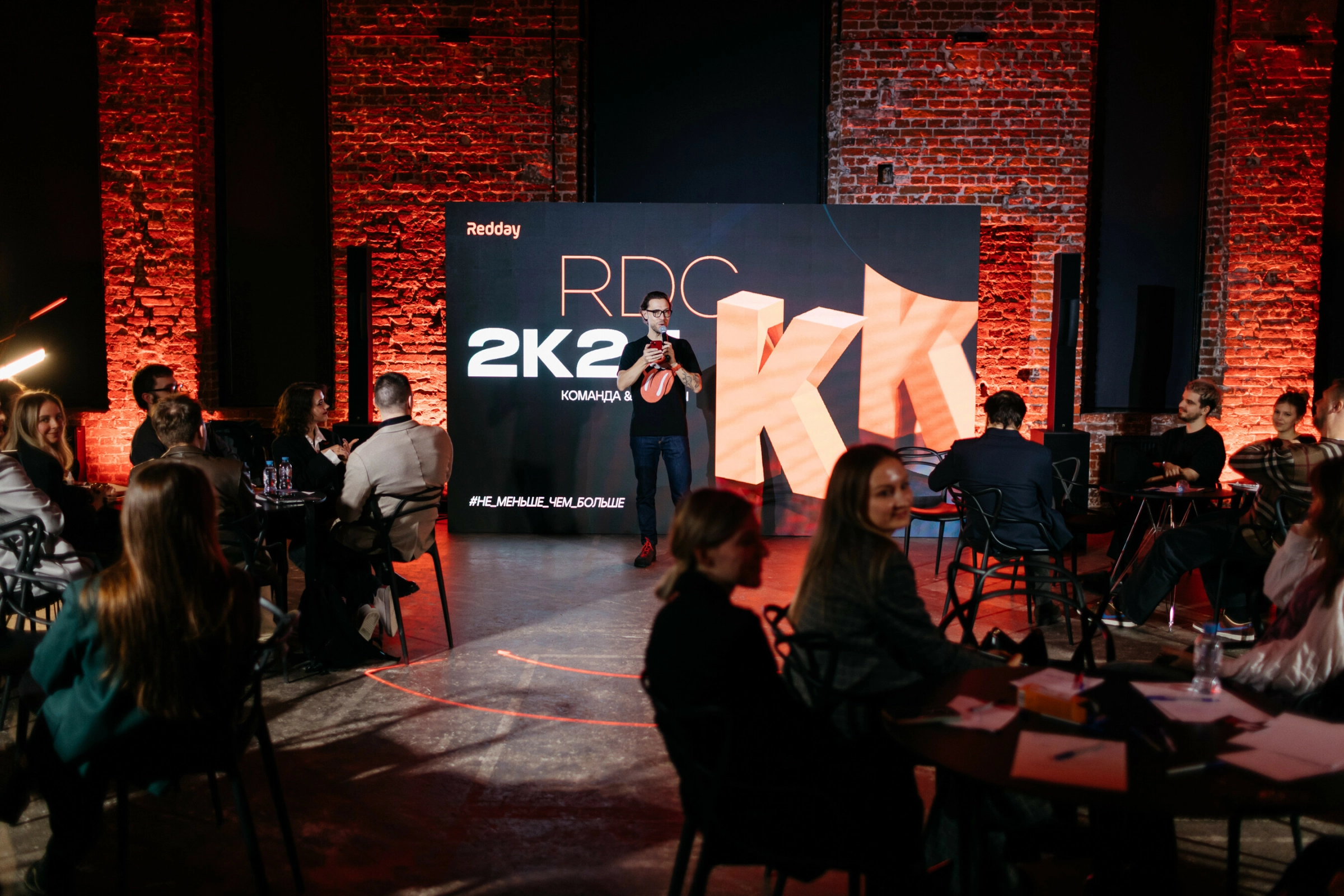 официантка подаёт закуски на фуршетной стойке в красном свете