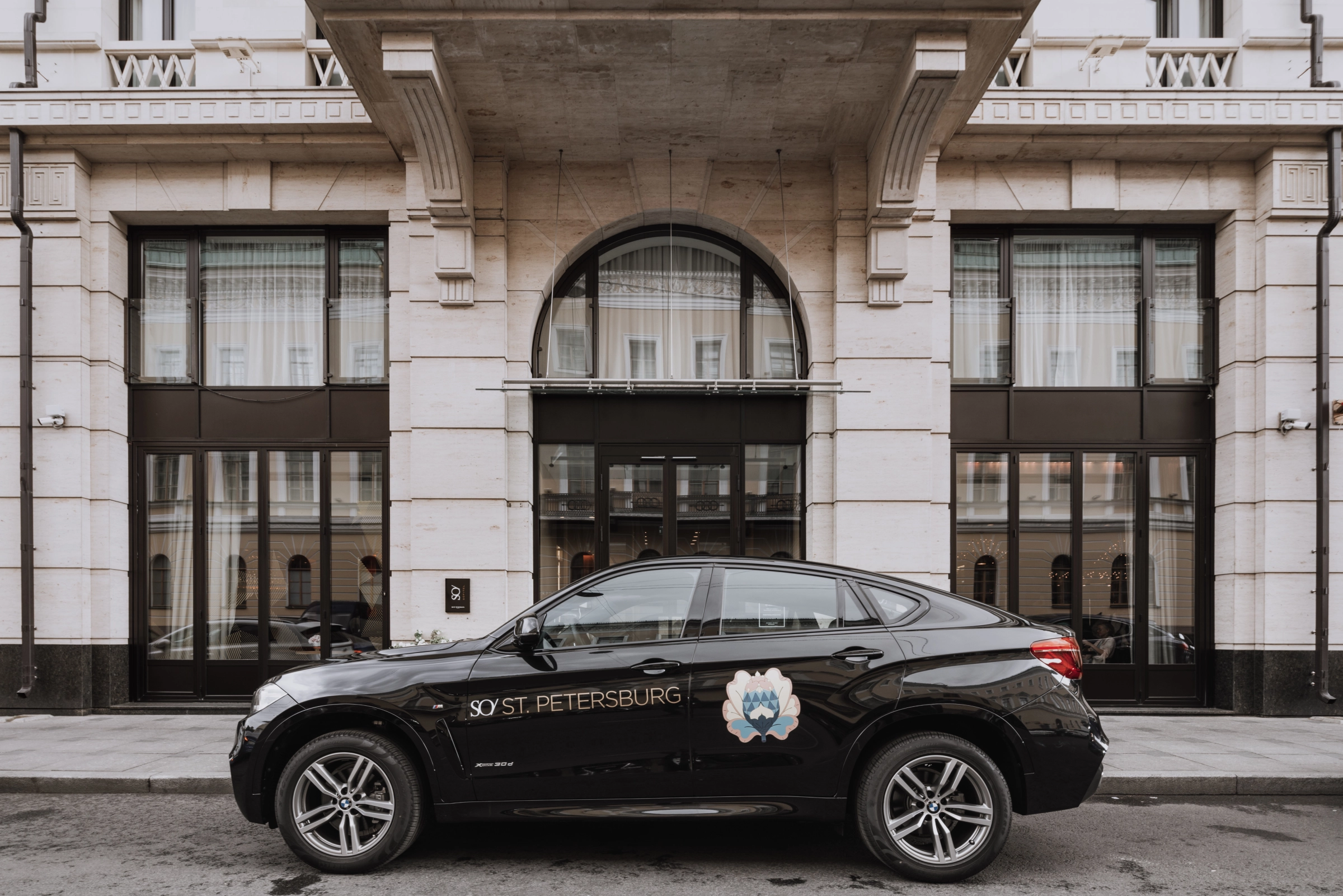 автомобиль с логотипом у входа в здание площадки на улице
