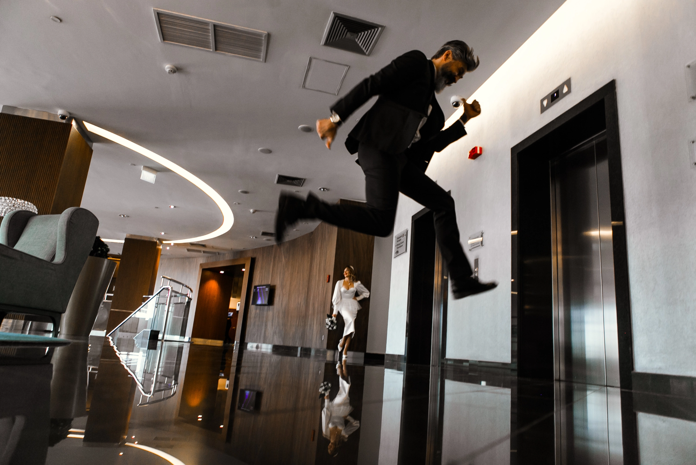 Жених в прыжке у лифтов в чёрно-глянцевом лобби отеля Radisson Blu