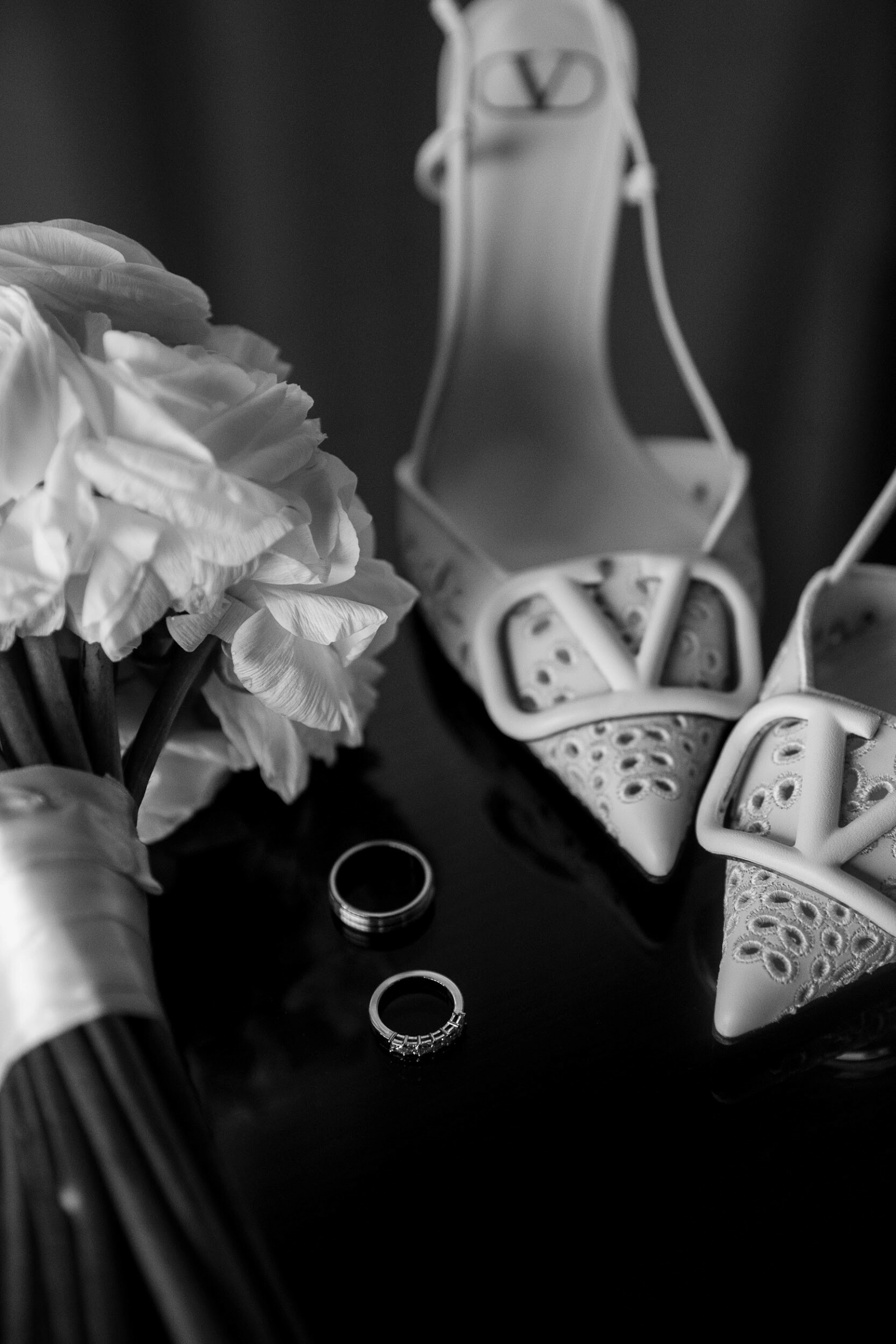 обручальные кольца и туфли valentino рядом с букетом невесты