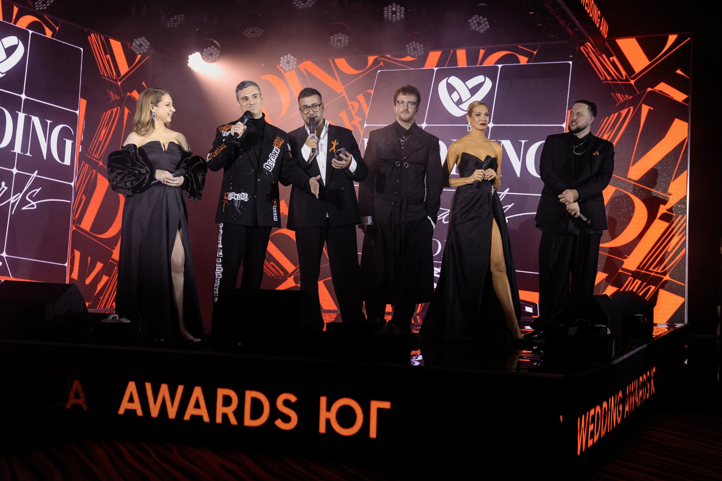 лауреаты премии Wedding Awards в чёрных нарядах на сцене с наградами