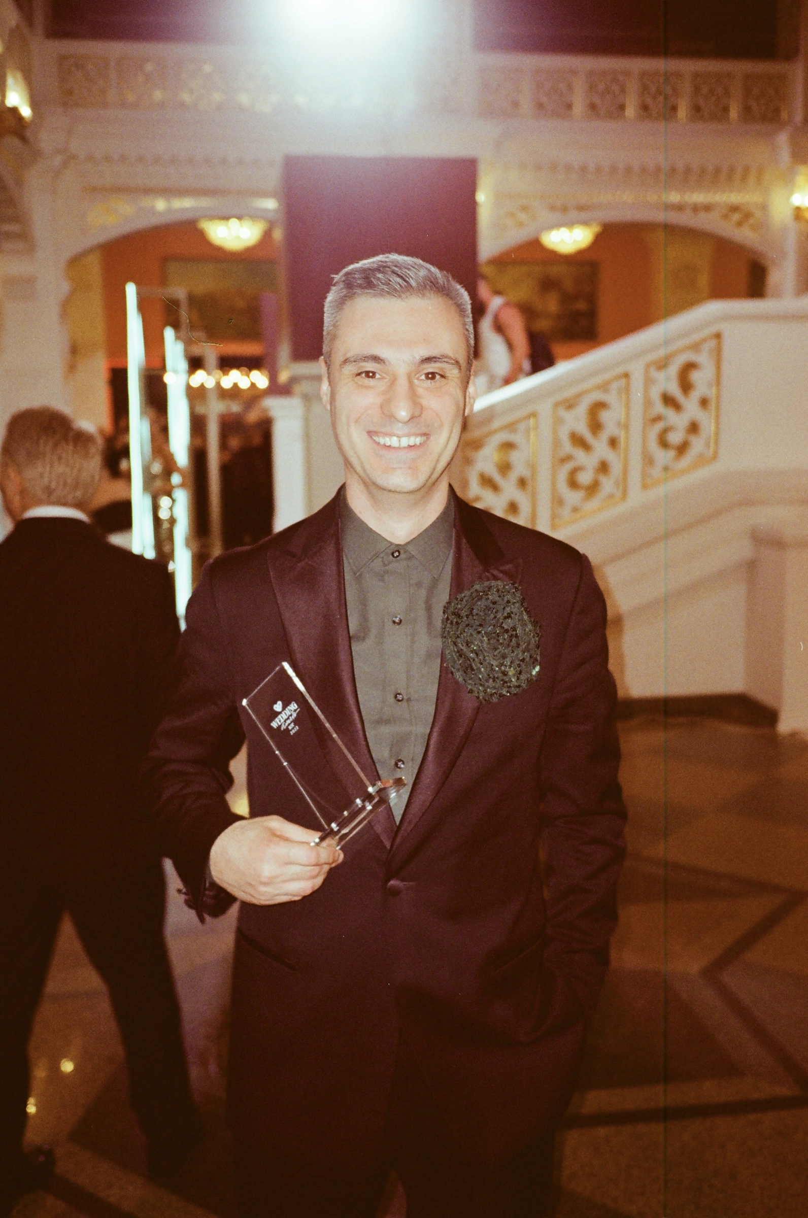 ведущий держит премию Wedding Awards в парадном холле отеля