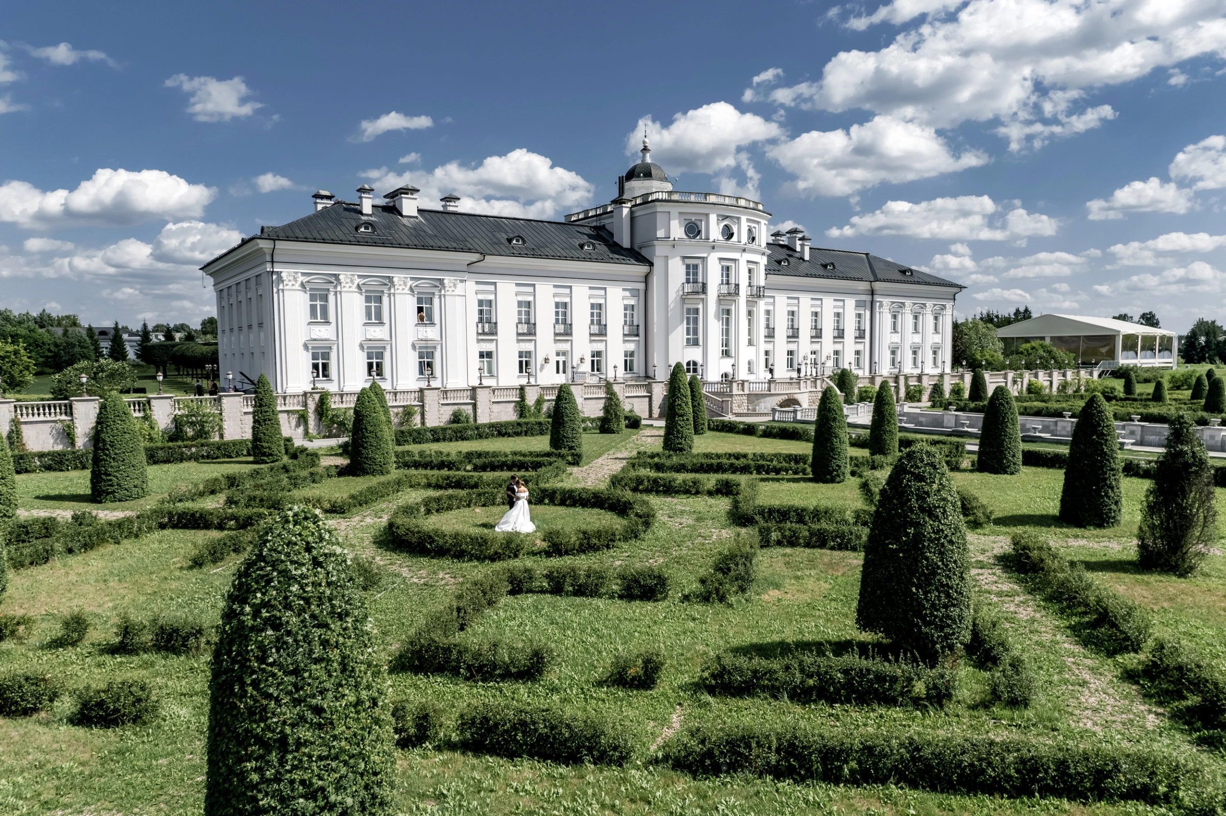 White baroque palazzo formal topiary garden sunny day