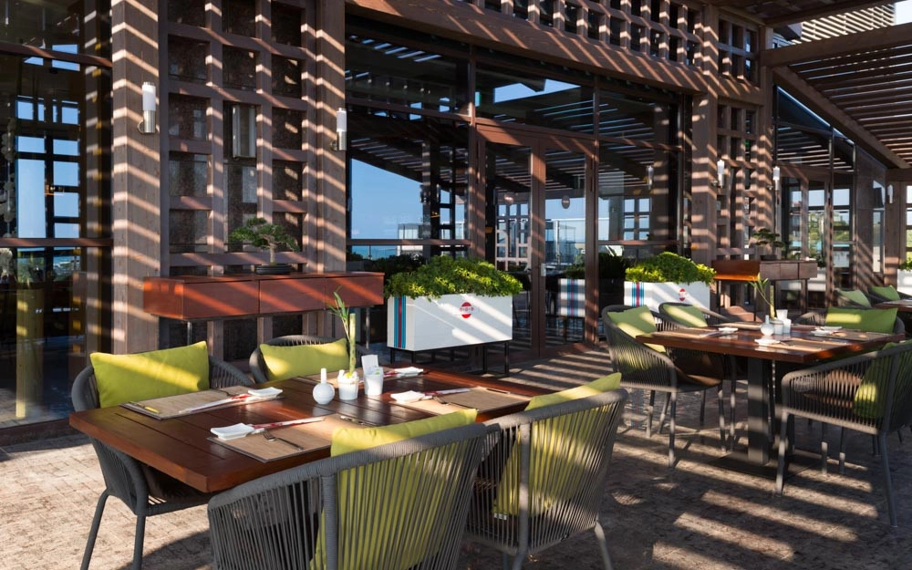 White pergola rooftop lounge with sea view and green accent cushions