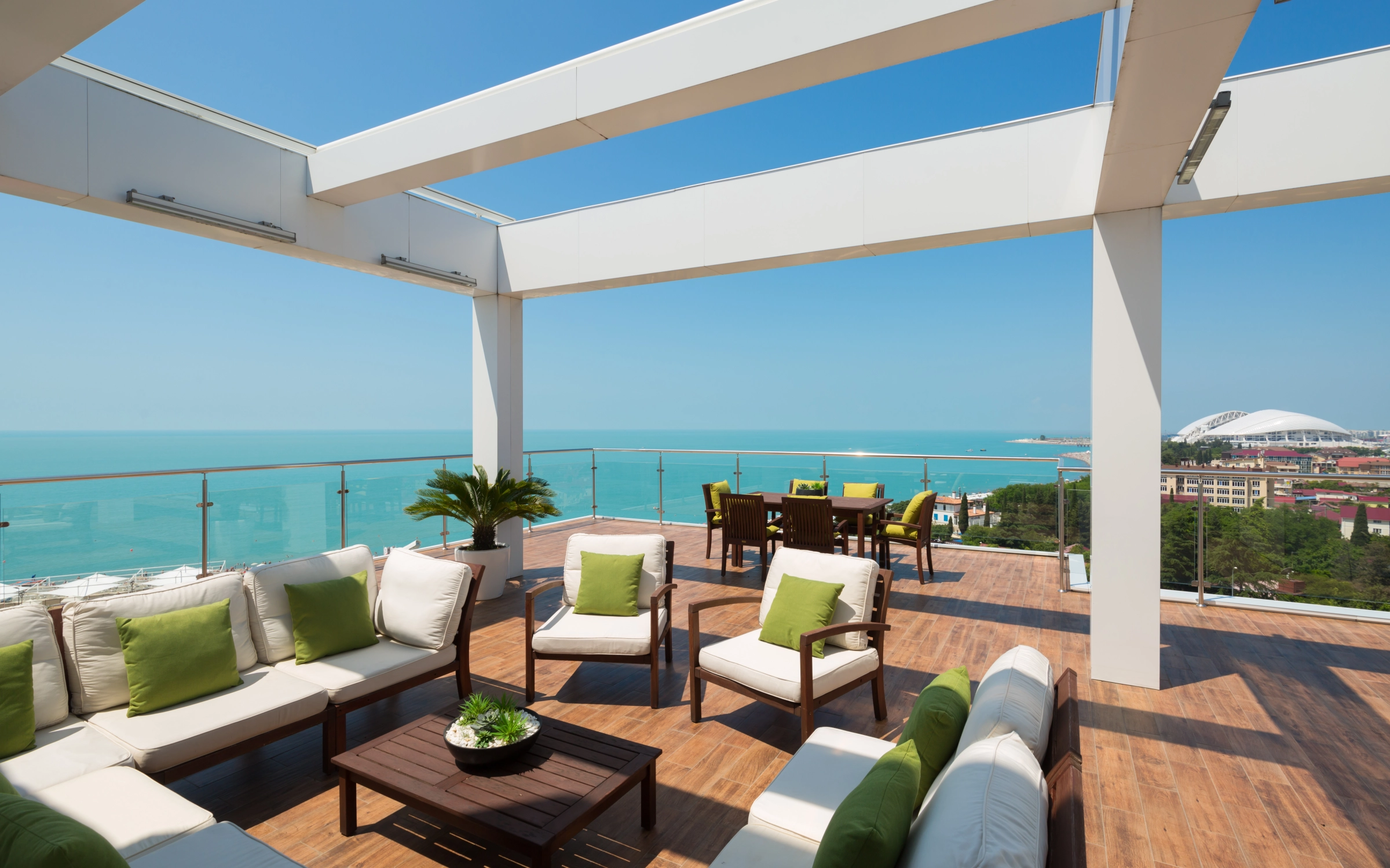 Rooftop lounge with modern white pergola sea view green cushion accents