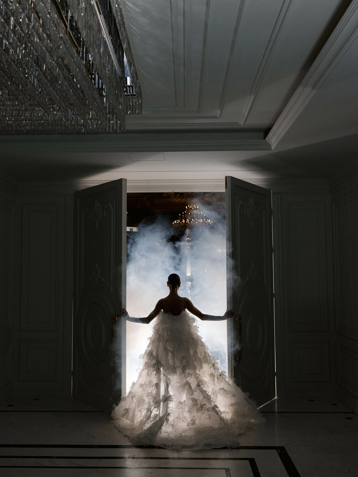 Bride flowing white train dramatic doorway venue lighting