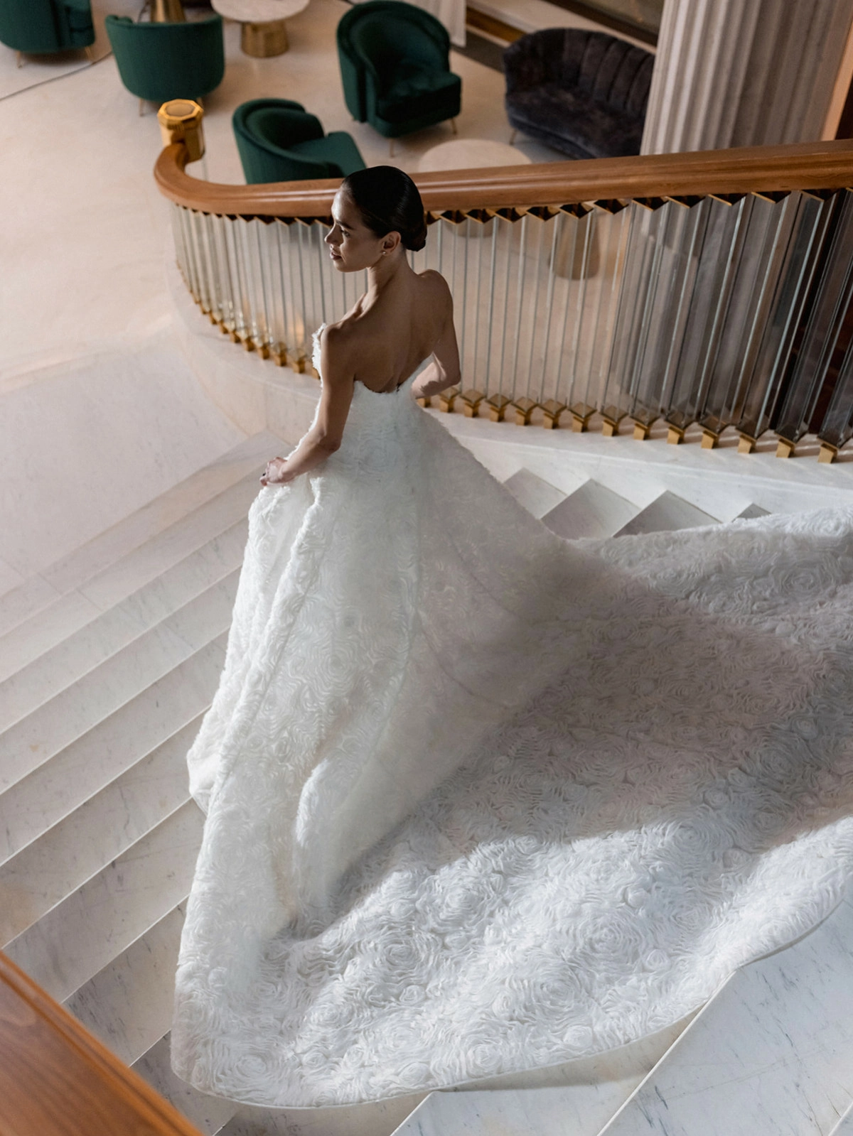 Bride white textured gown golden staircase railing venue