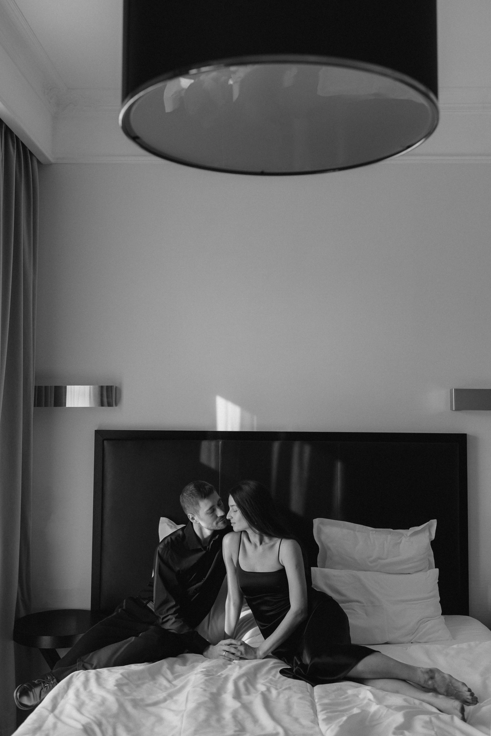 Мужчина и женщина сидят на кровати в современной спальне
