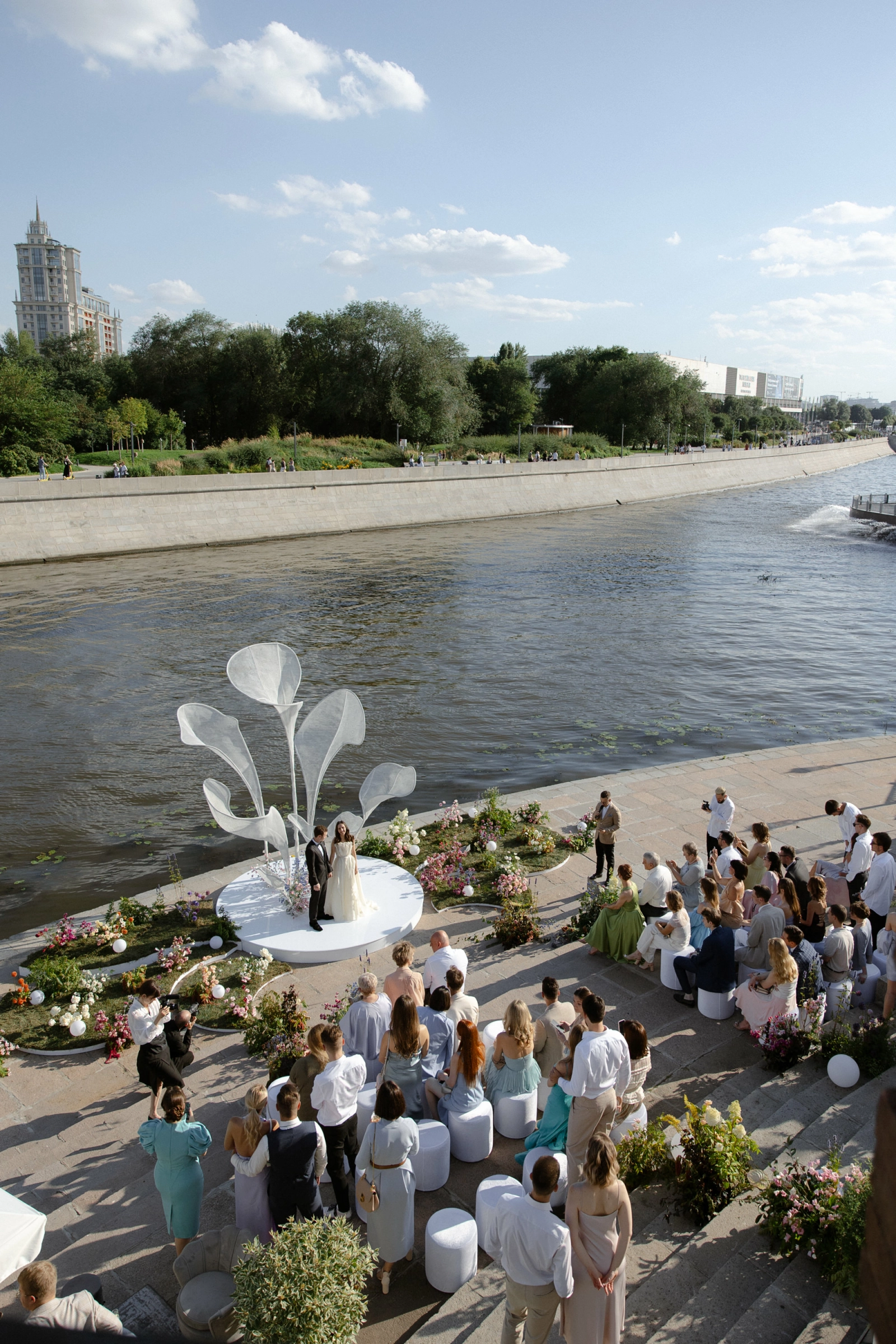 Свадебная церемония у реки с белой аркой и лентами