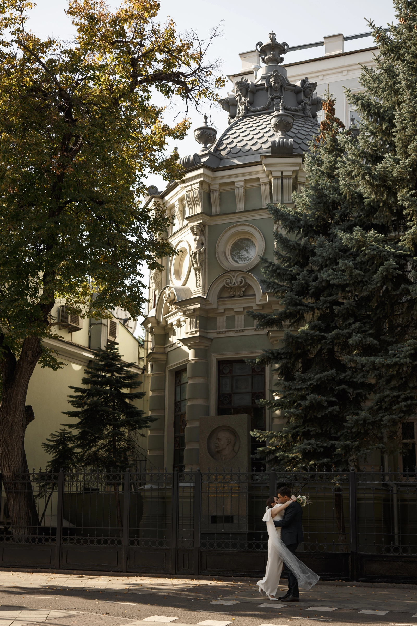поцелуй пары на фоне старинного особняка с башенкой