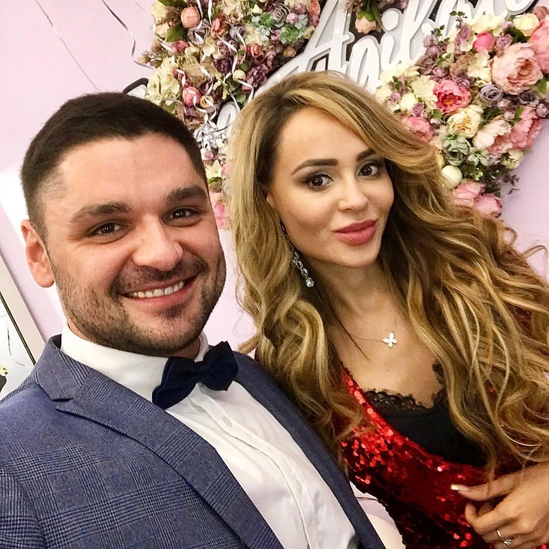 ведущий с гостьей на фоне праздничного цветочного декора