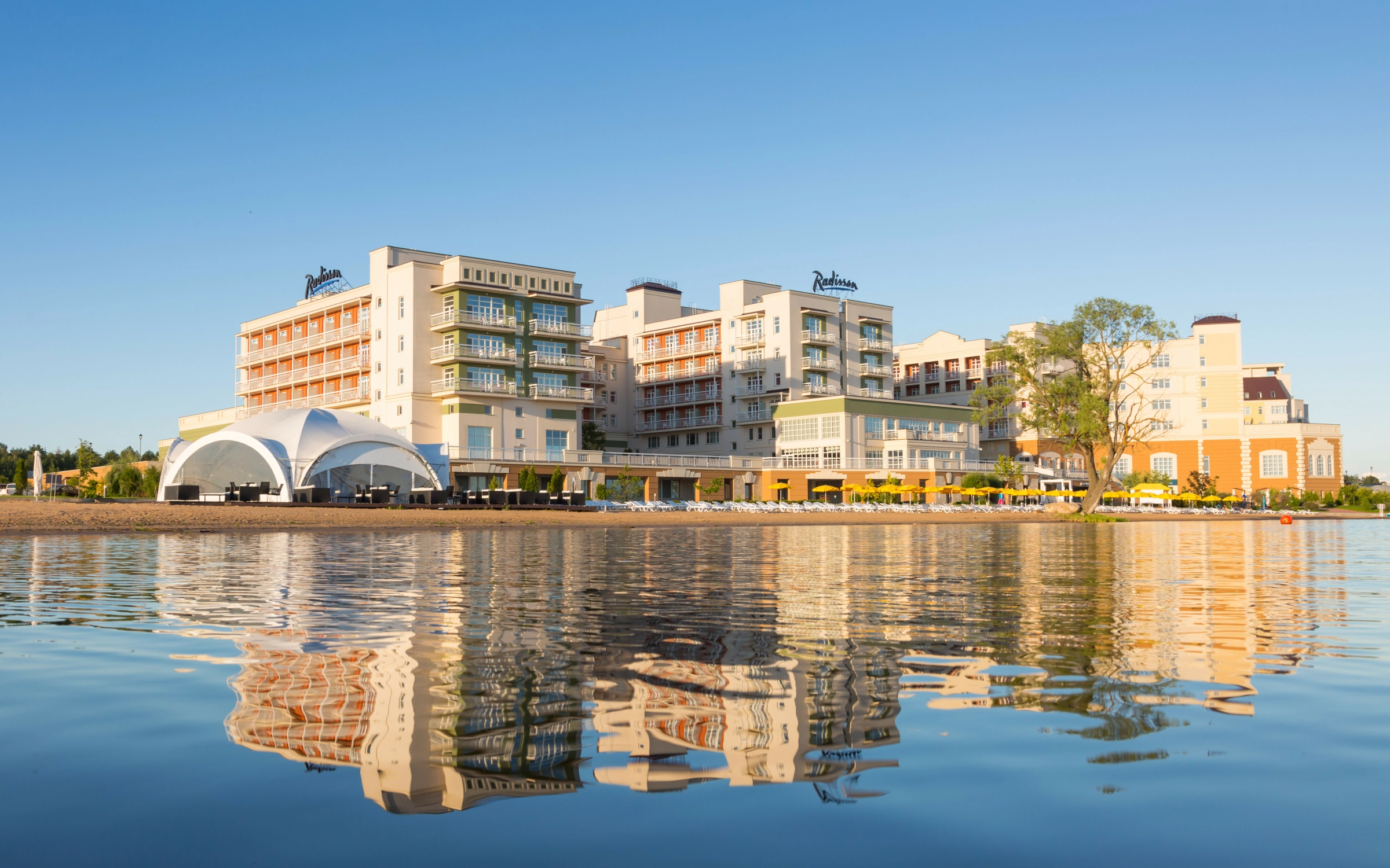 отель Radisson на берегу водоёма с белым шатром-куполом