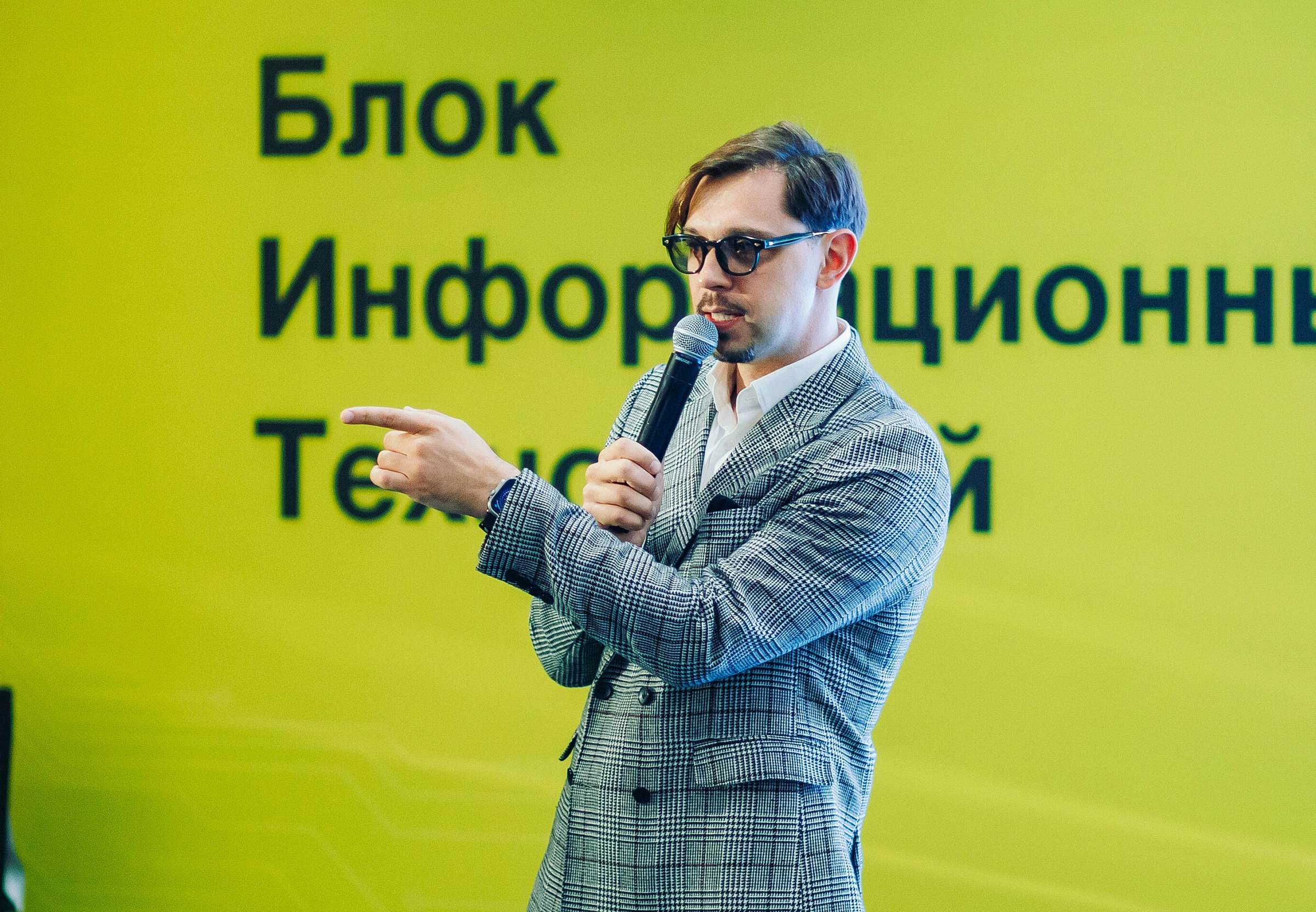 ведущий мероприятий с микрофоном на сцене во время выступления