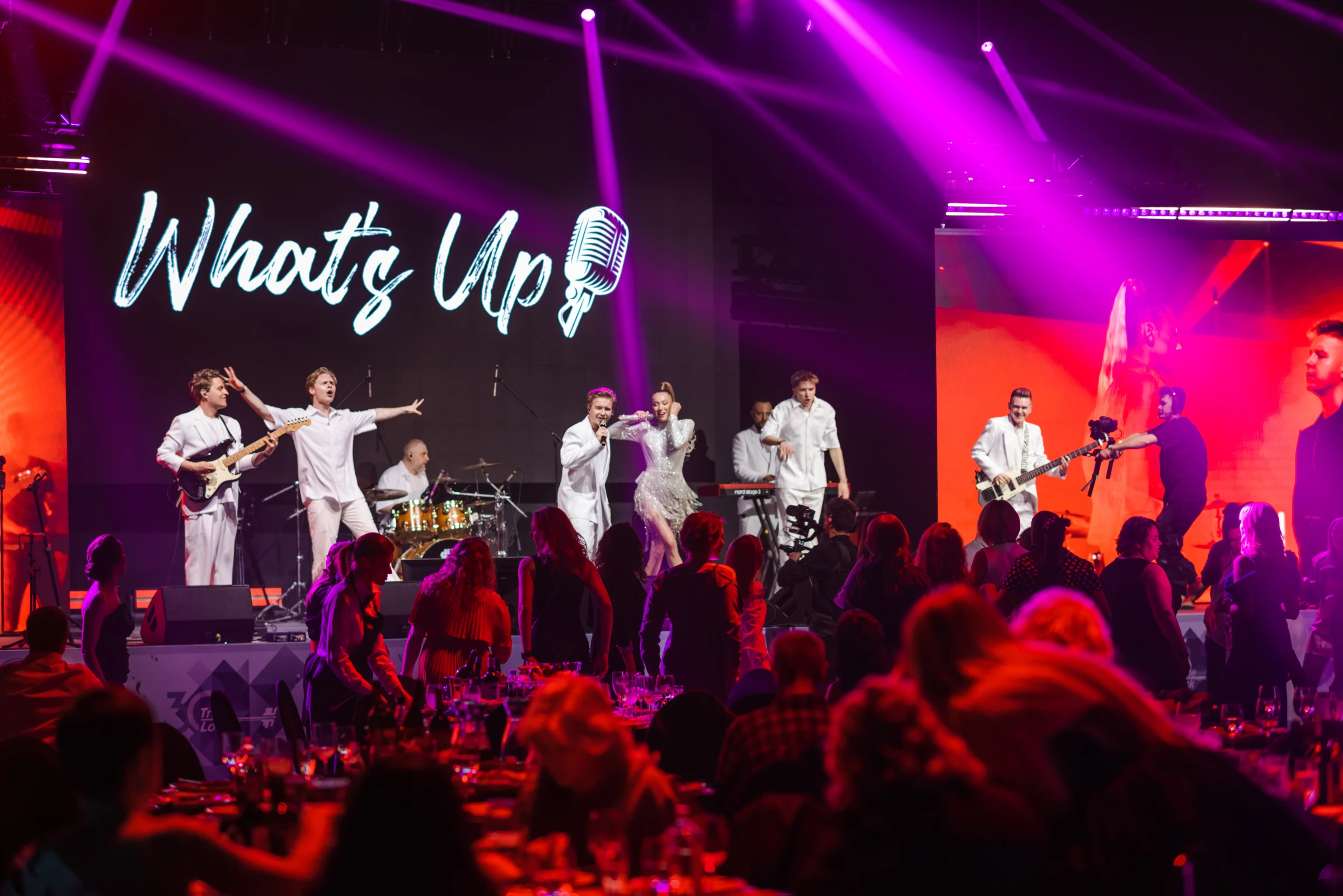 Музыканты WHAT'S UP в белых костюмах выступают на сцене перед гостями