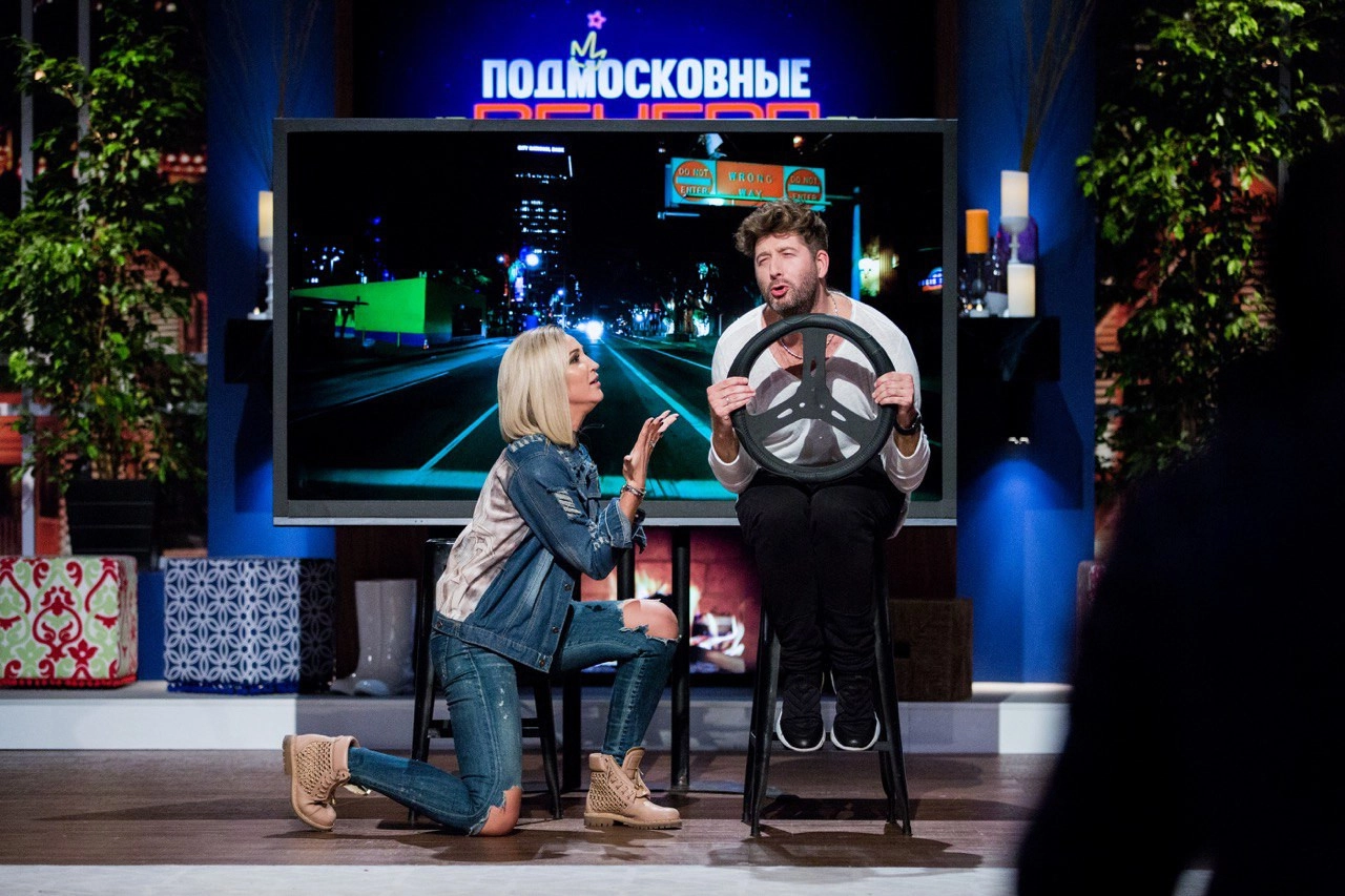Ведущий в костюме говорит в микрофон сцена