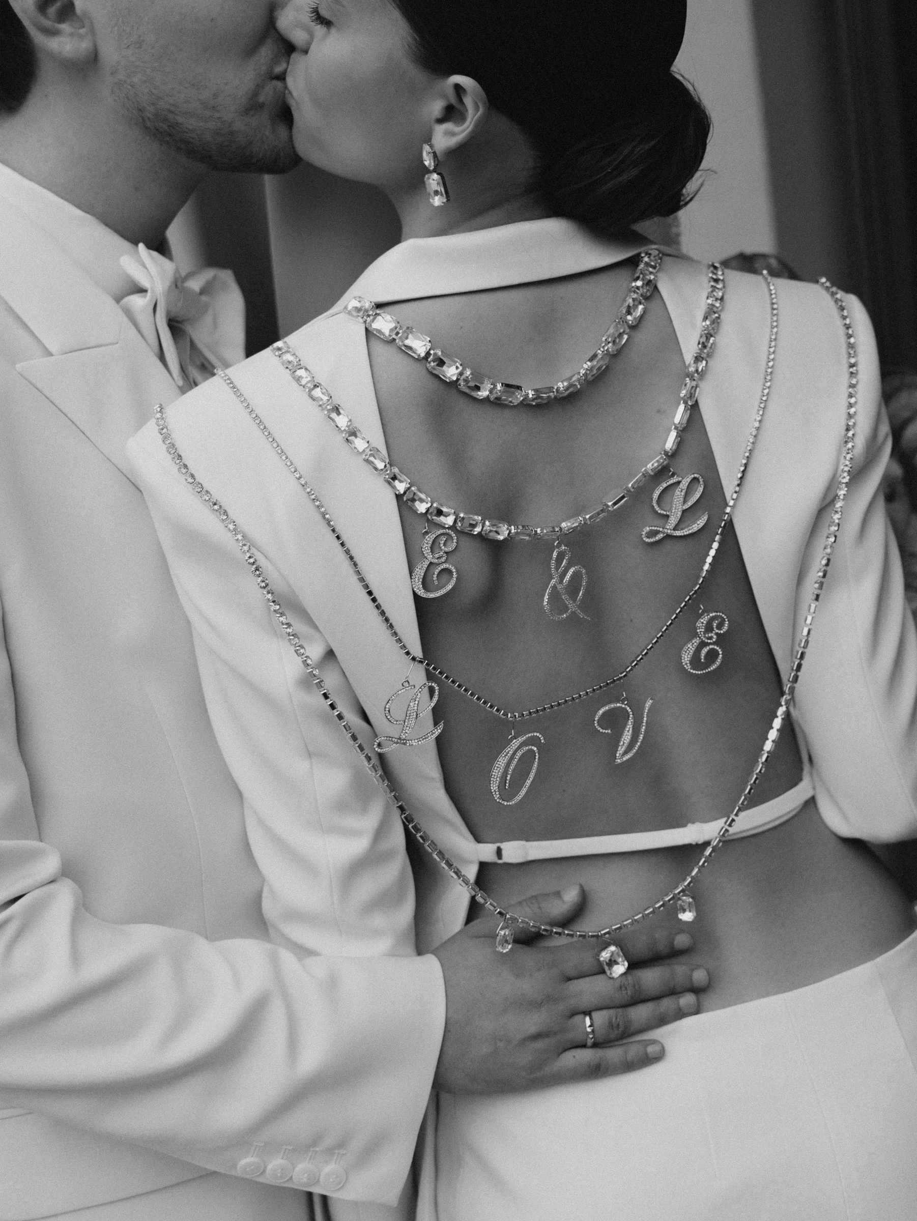 жених целует невесту крупным планом со свадебными цепочками love на спине