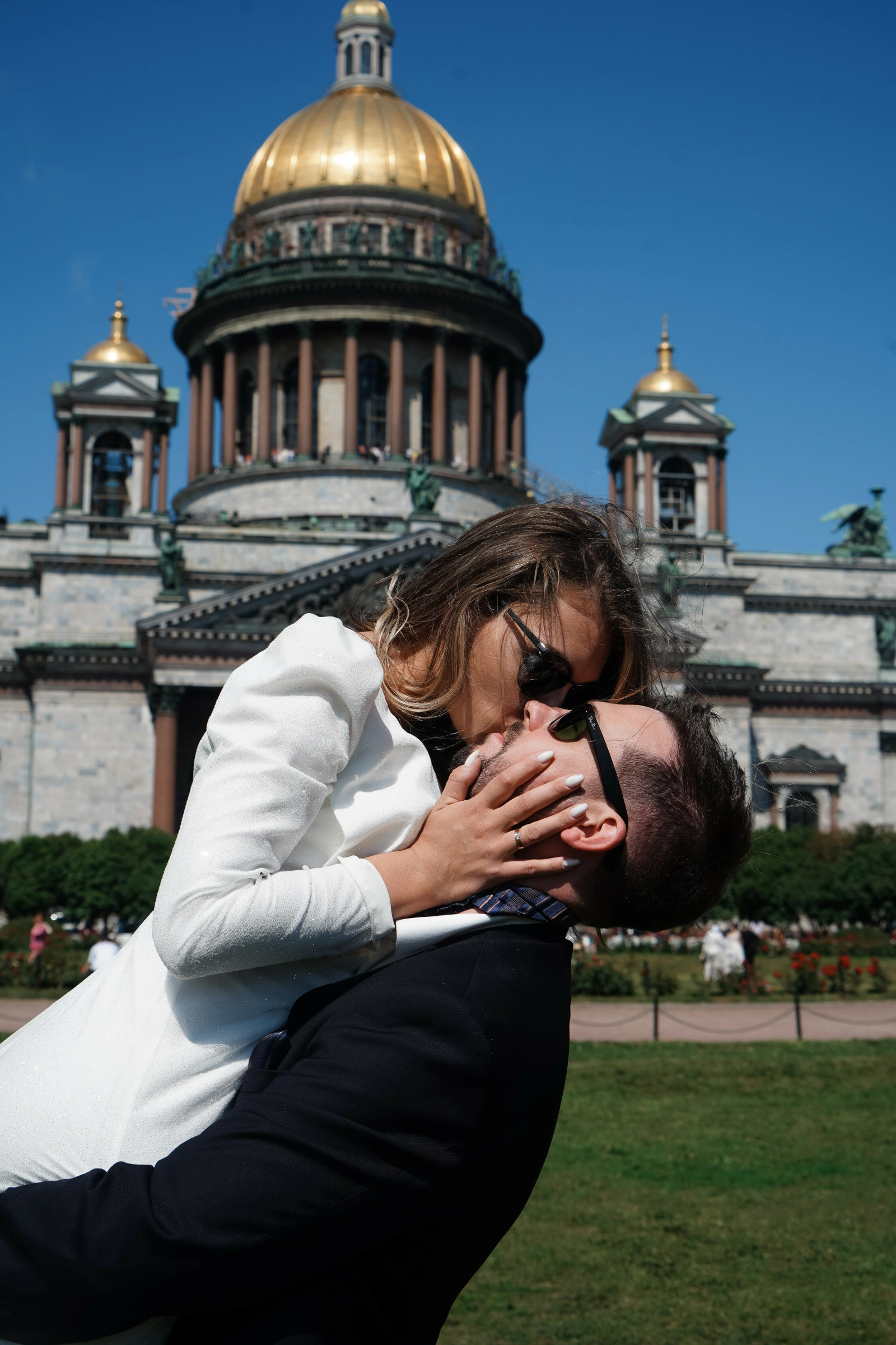 Мужчина держит на руках женщину для поцелуя перед историческим собором в центре