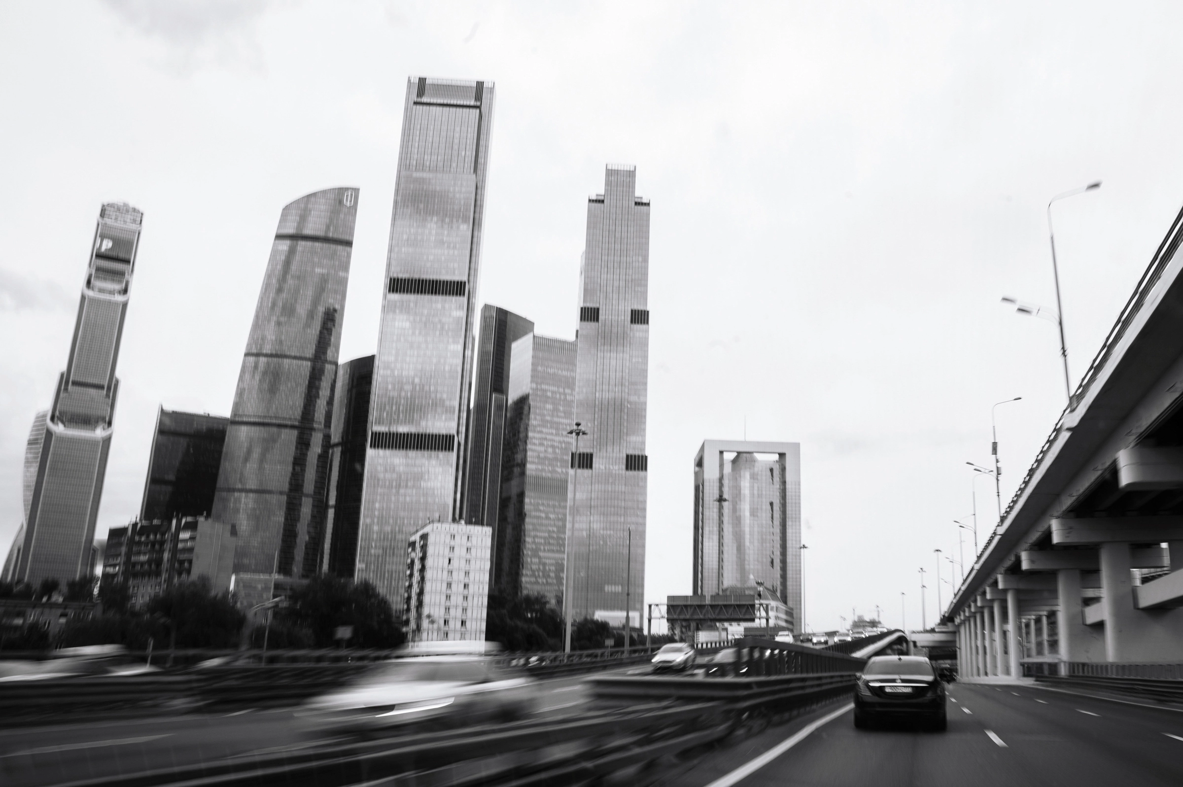 Высотные стеклянные здания возвышаются над оживлённой многополосной автомагистралью города