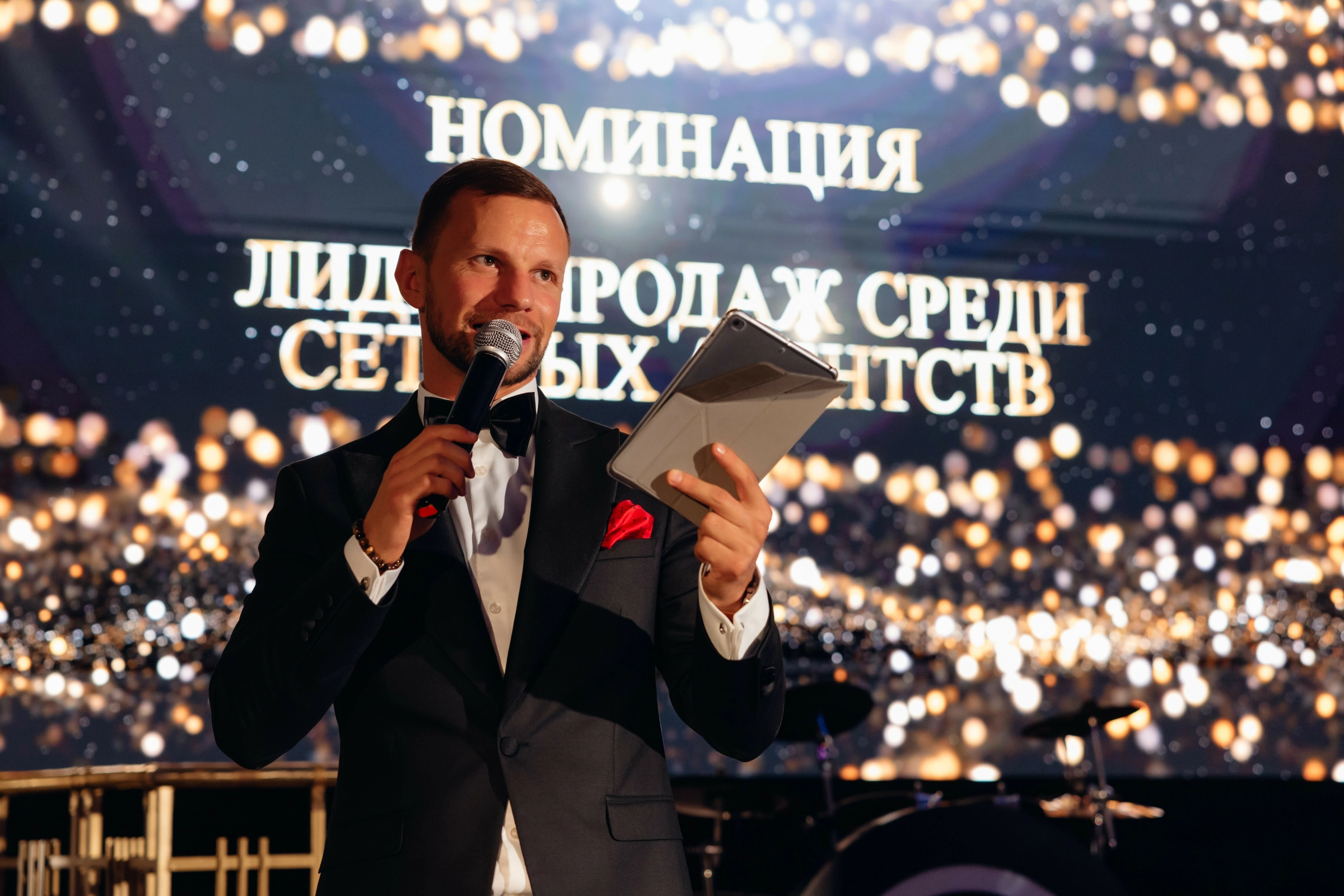 Текст очередной номинации крупно проецируется на большом экране позади сцены