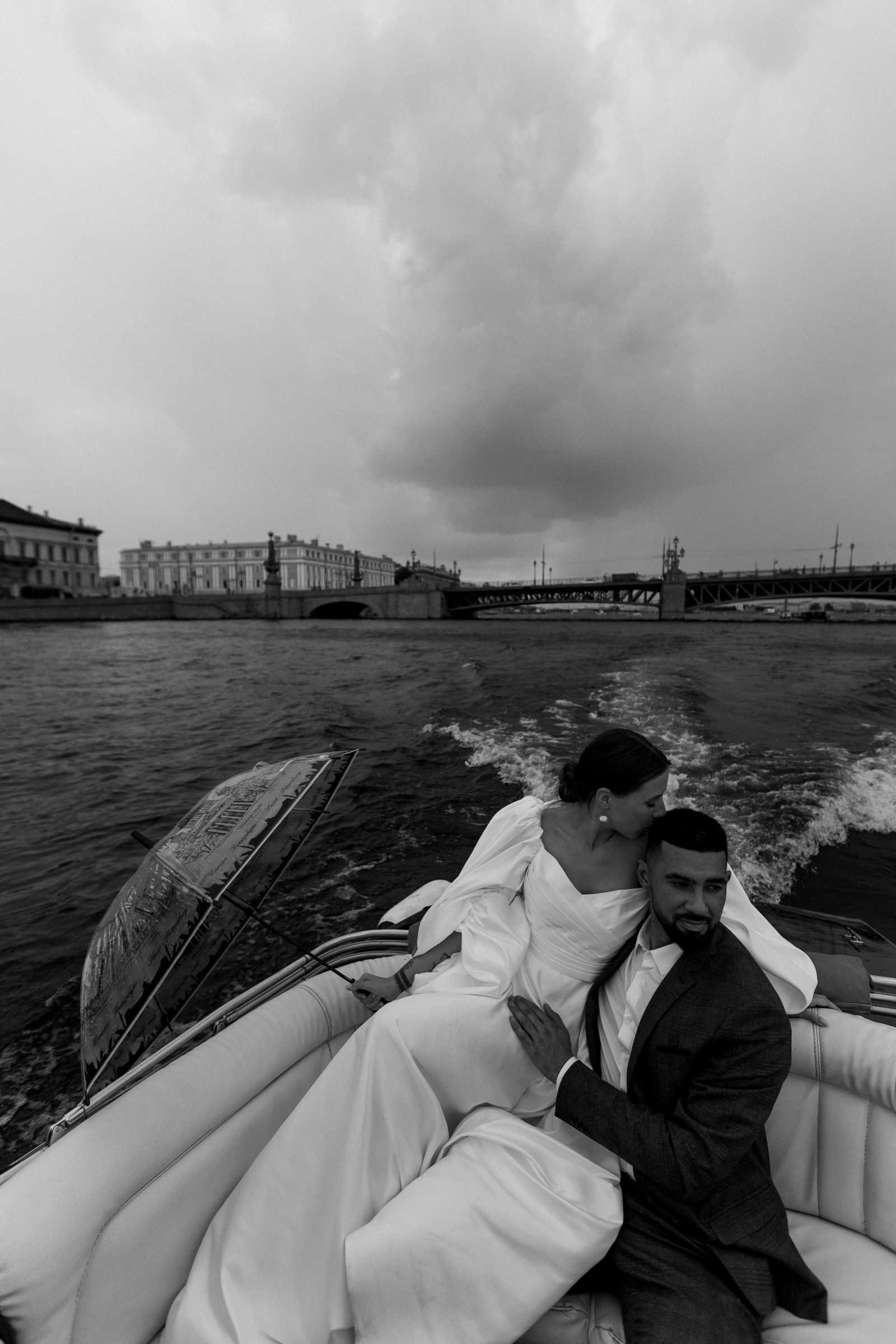 Прозрачный зонт лежит рядом с парой на сиденье лодки во время речной прогулки