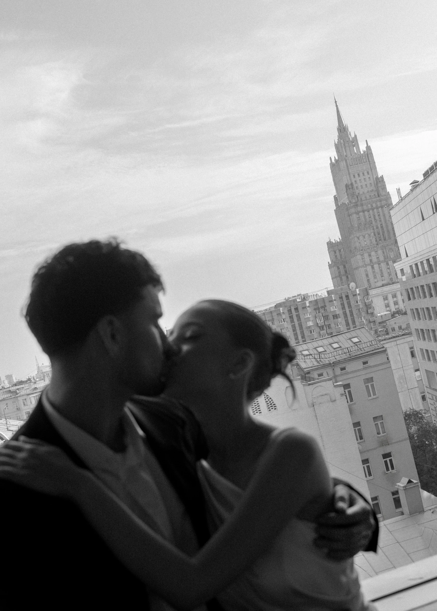 поцелуй жениха и невесты на фоне высотных зданий Москвы чёрно-белое фото