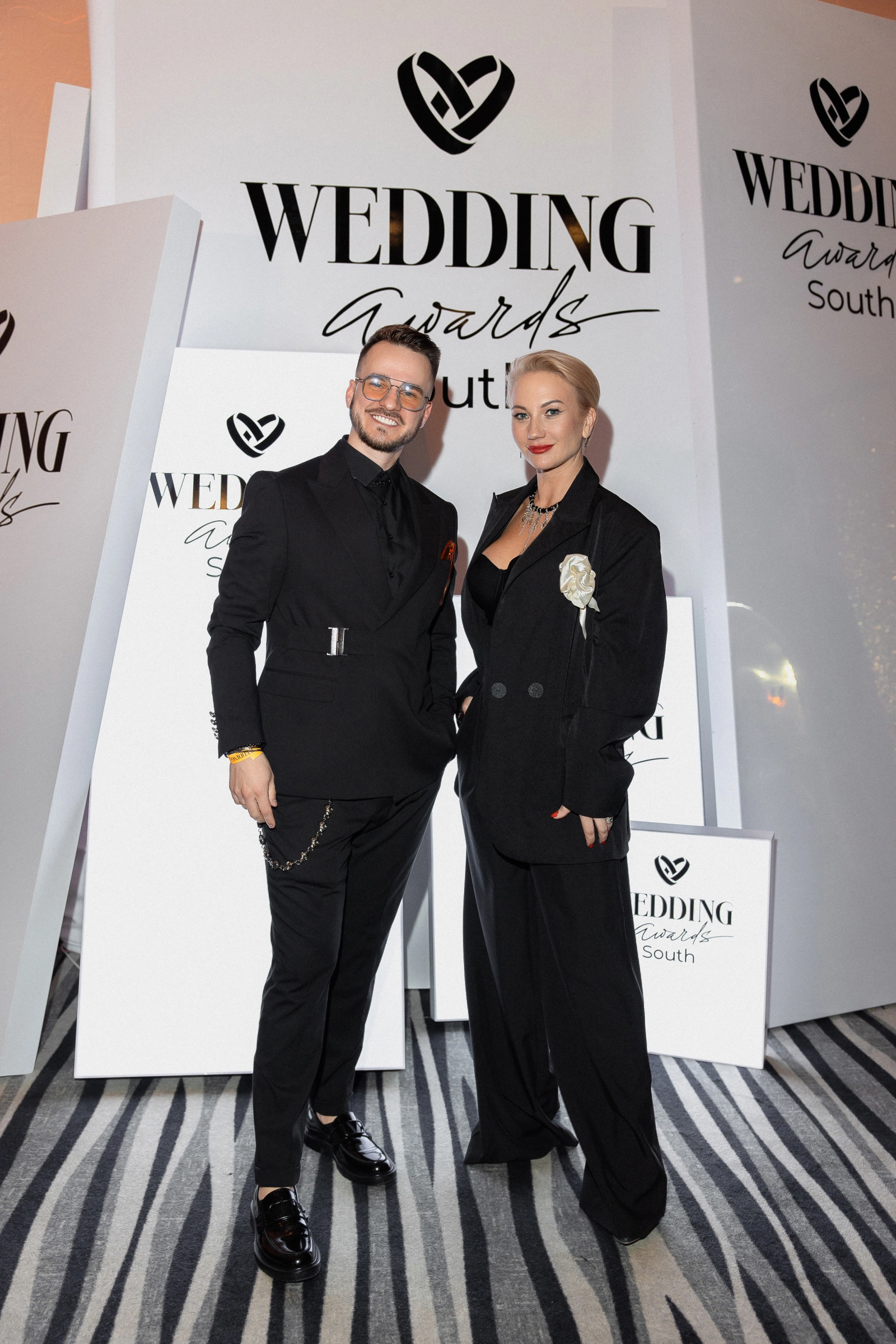 ведущий свадеб в чёрном костюме на фотозоне премии Wedding Awards