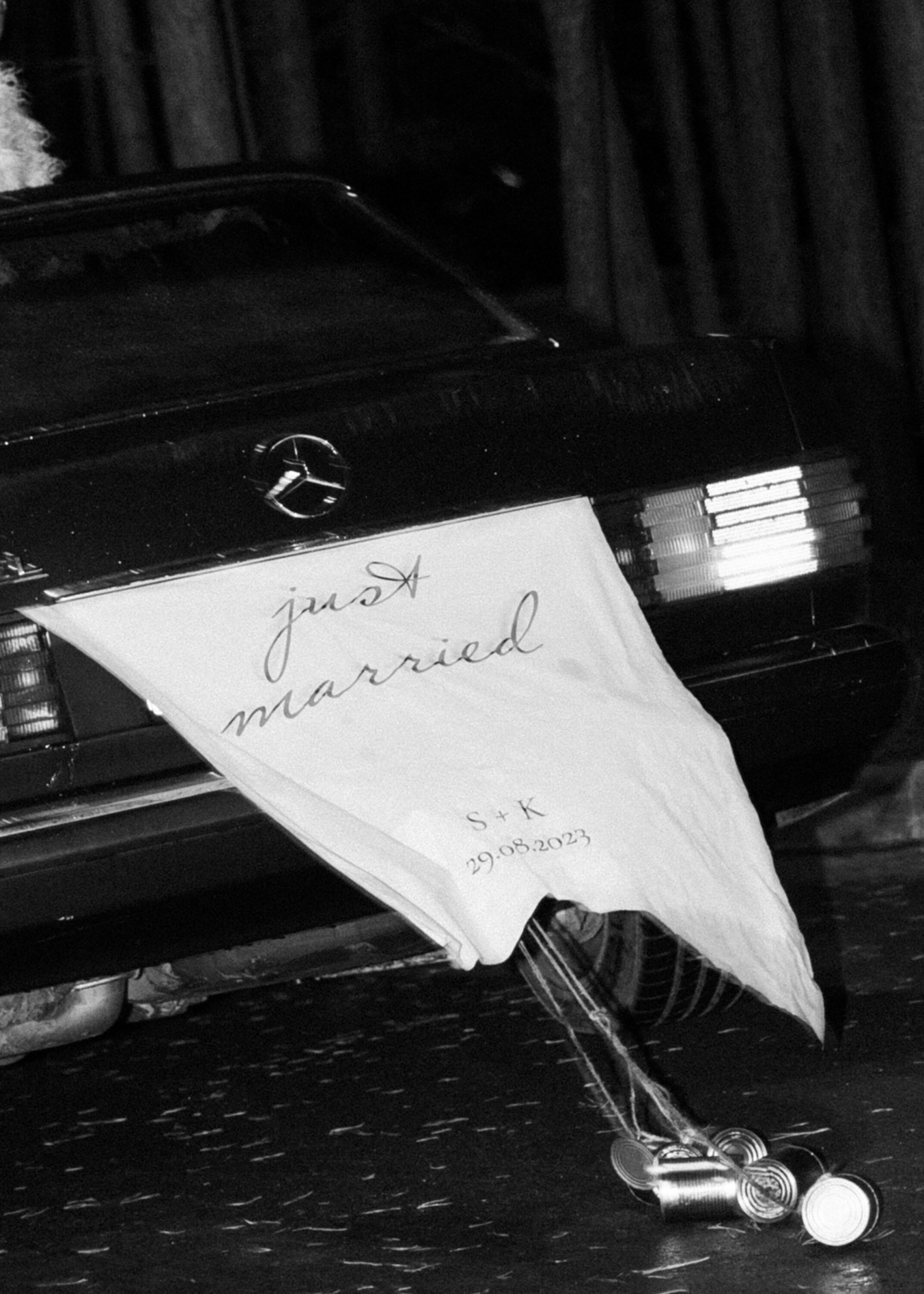 табличка Just Married на заднем стекле винтажного чёрного автомобиля