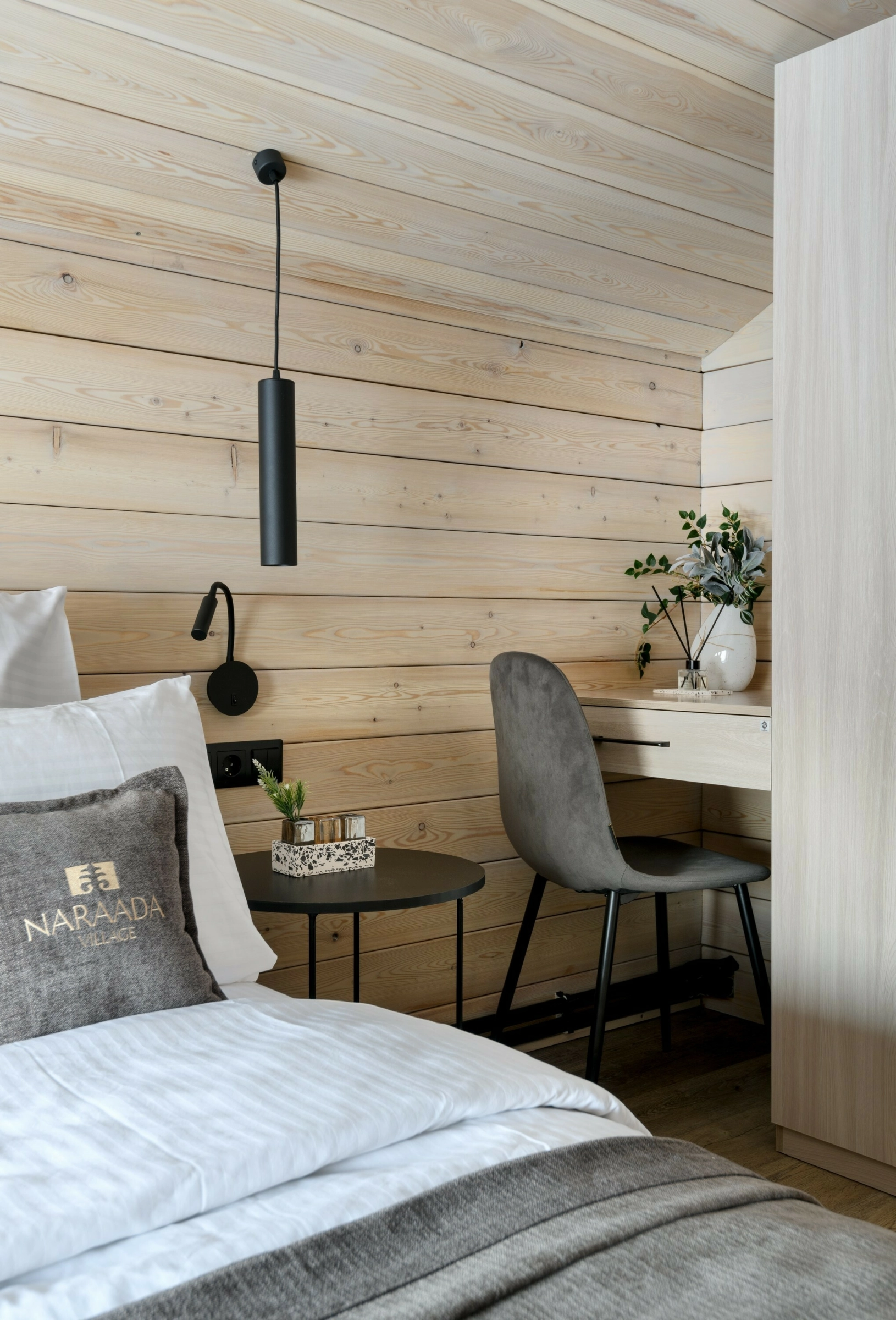 Настенное бра над круглым тумбочным столиком у кровати