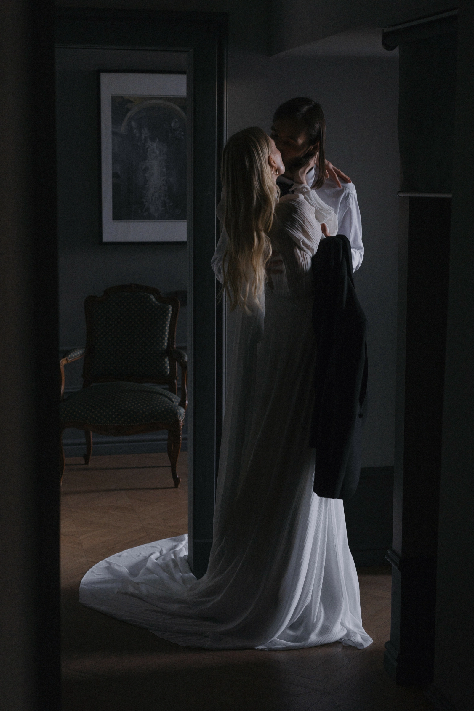 невеста и жених целуются в дверном проёме гостиной вечером