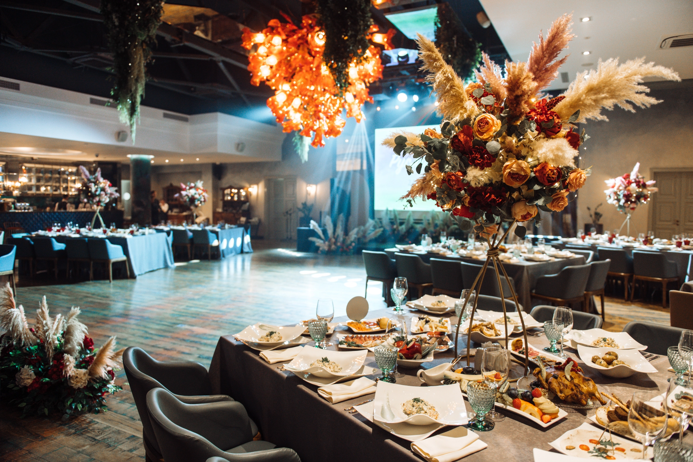 банкетный зал со столами и композициями из роз и пампасной травы