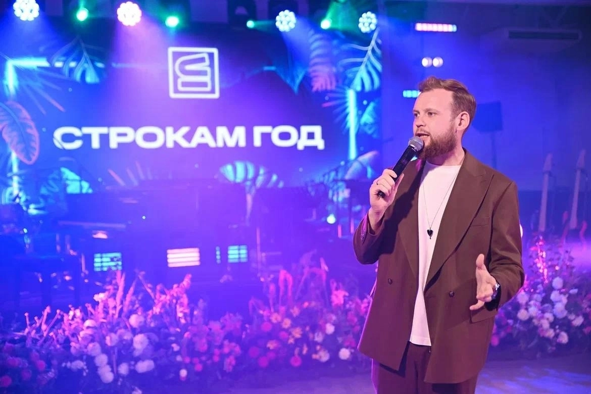 два артиста с микрофонами стоят рядом с большим экраном