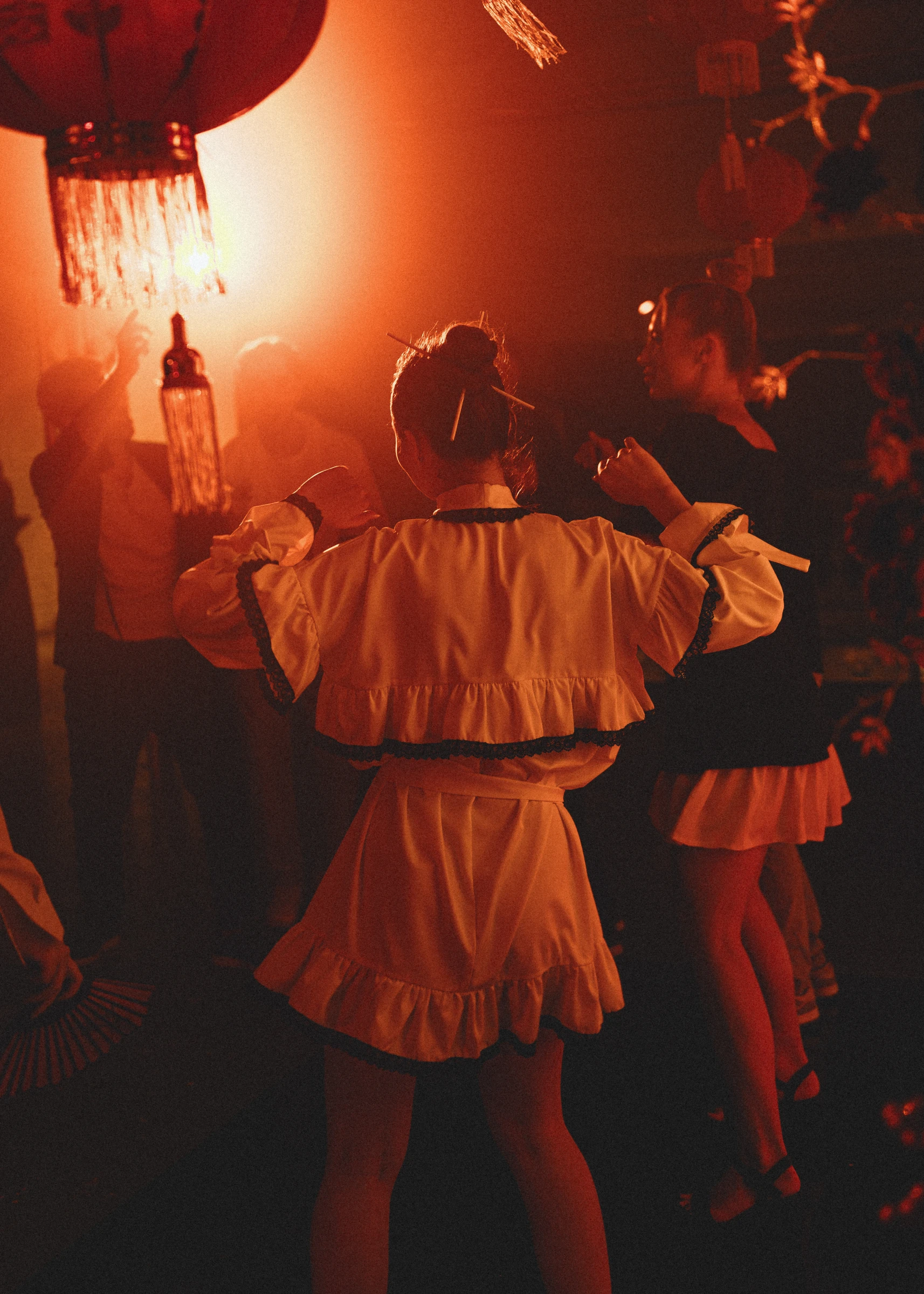 гостья танцует в оранжевом свете фонарей на afterparty