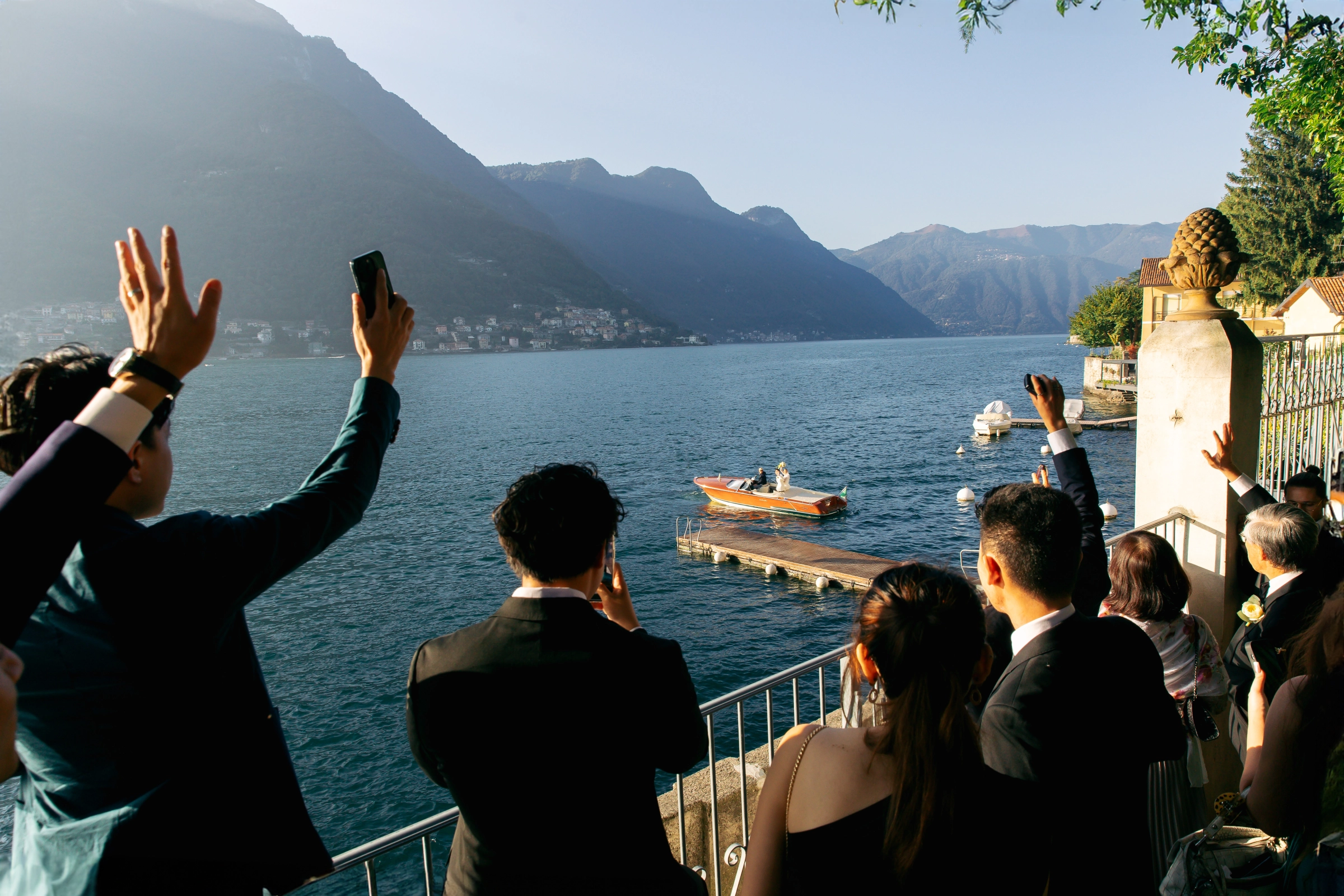 Гости на террасе встречают катер с молодожёнами на горном озере