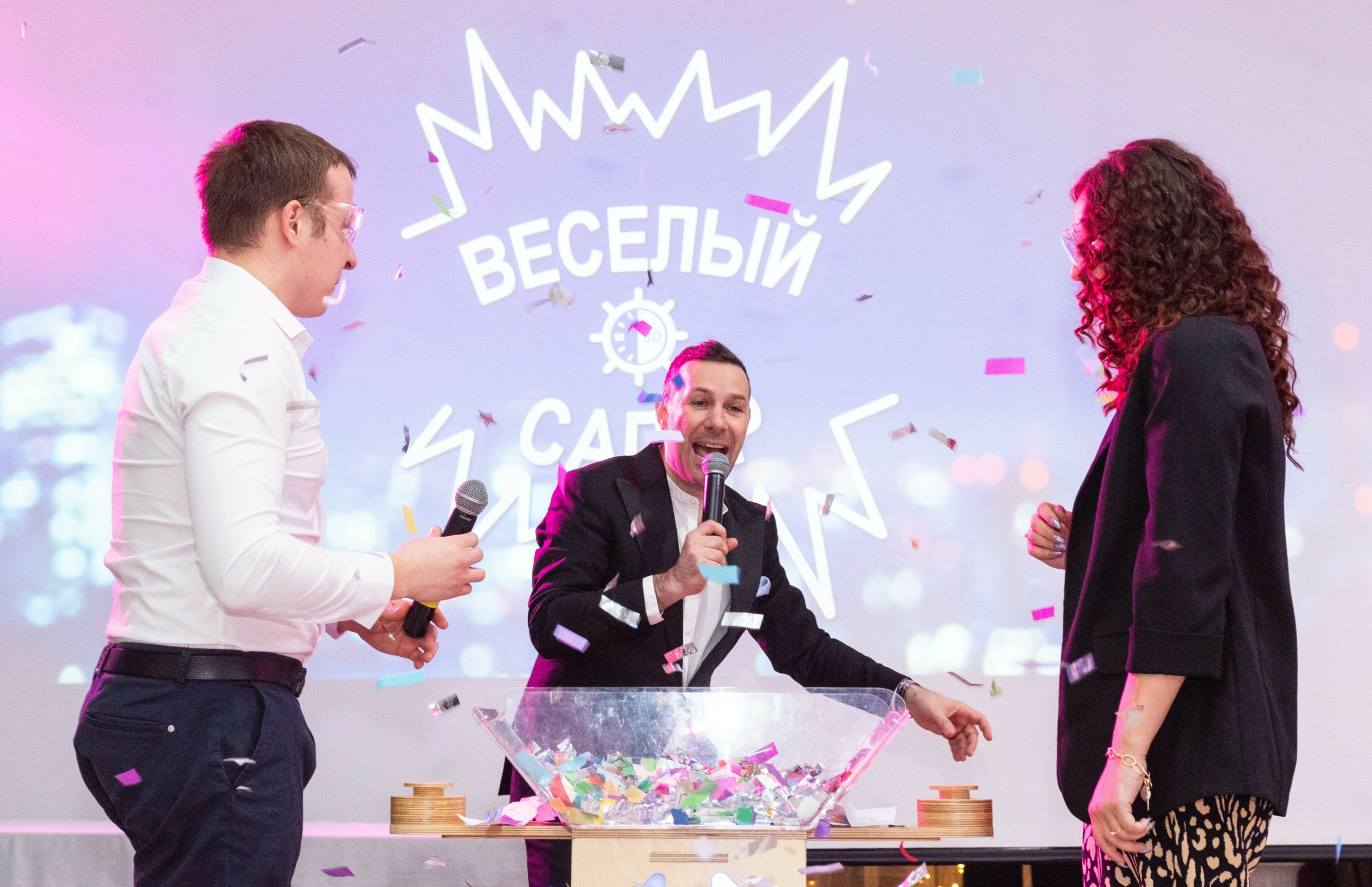 ведущий проводит конкурс с конфетти на банкете вместе с гостями