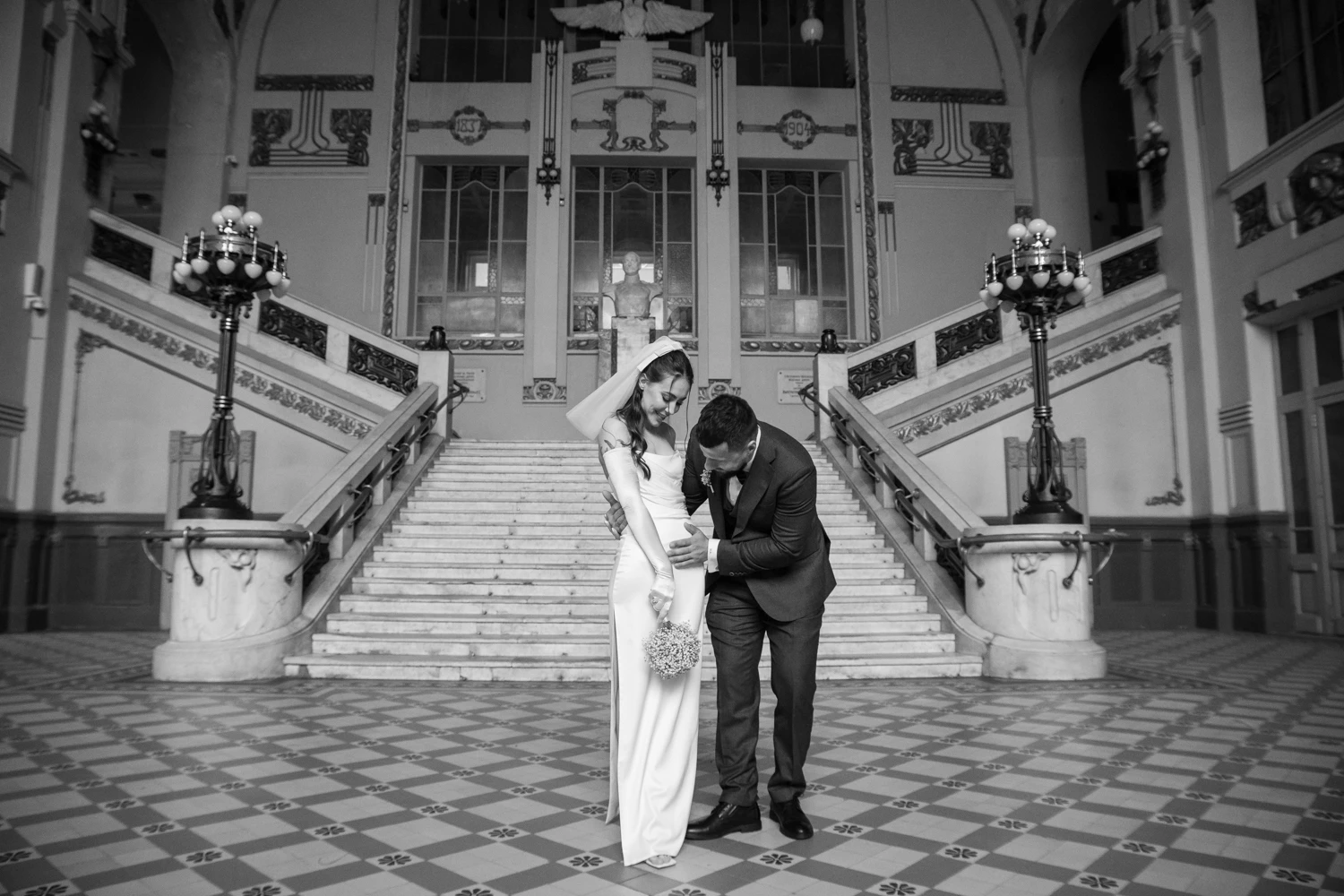 пара в центре симметричной парадной лестницы исторического вокзала