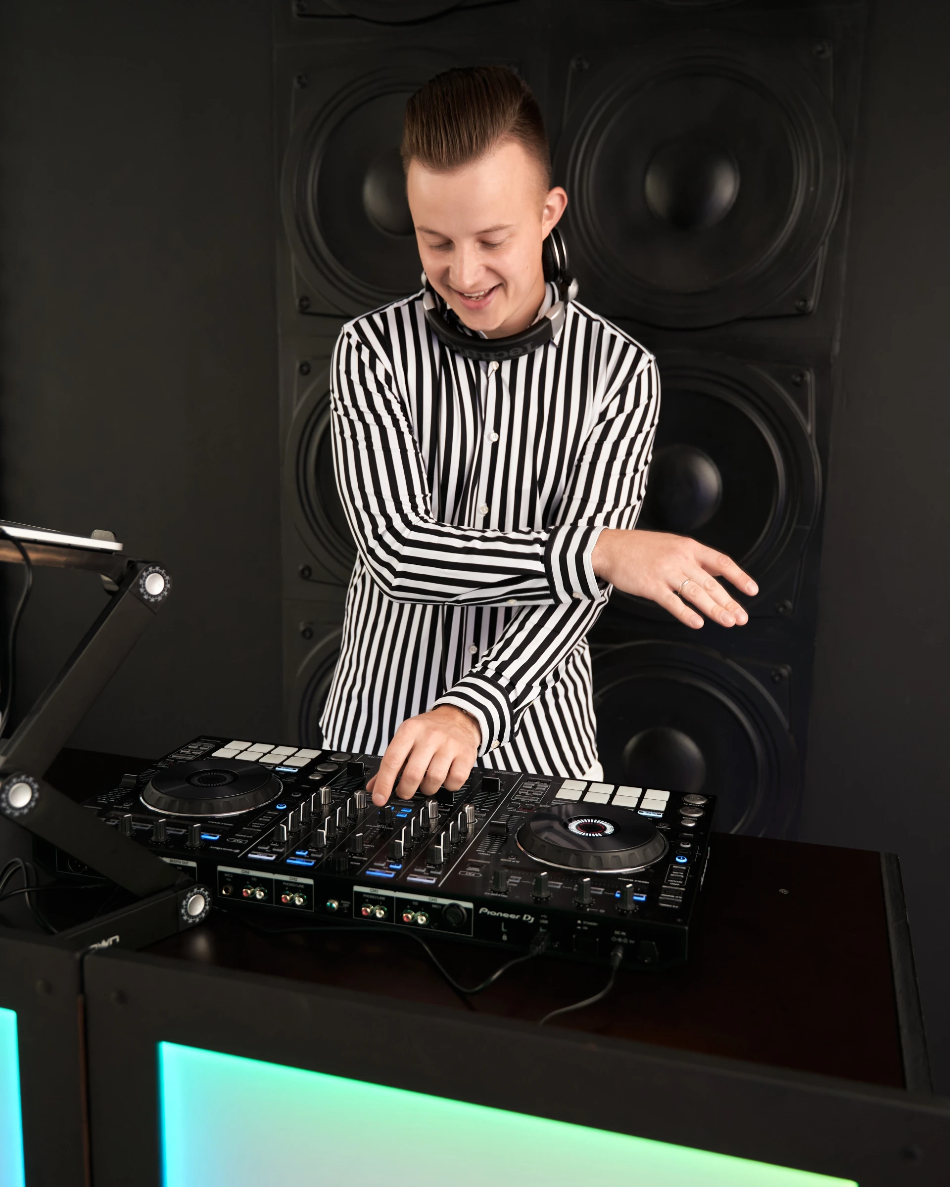 Диджей в полосатой рубашке работает за диджейским пультом Pioneer