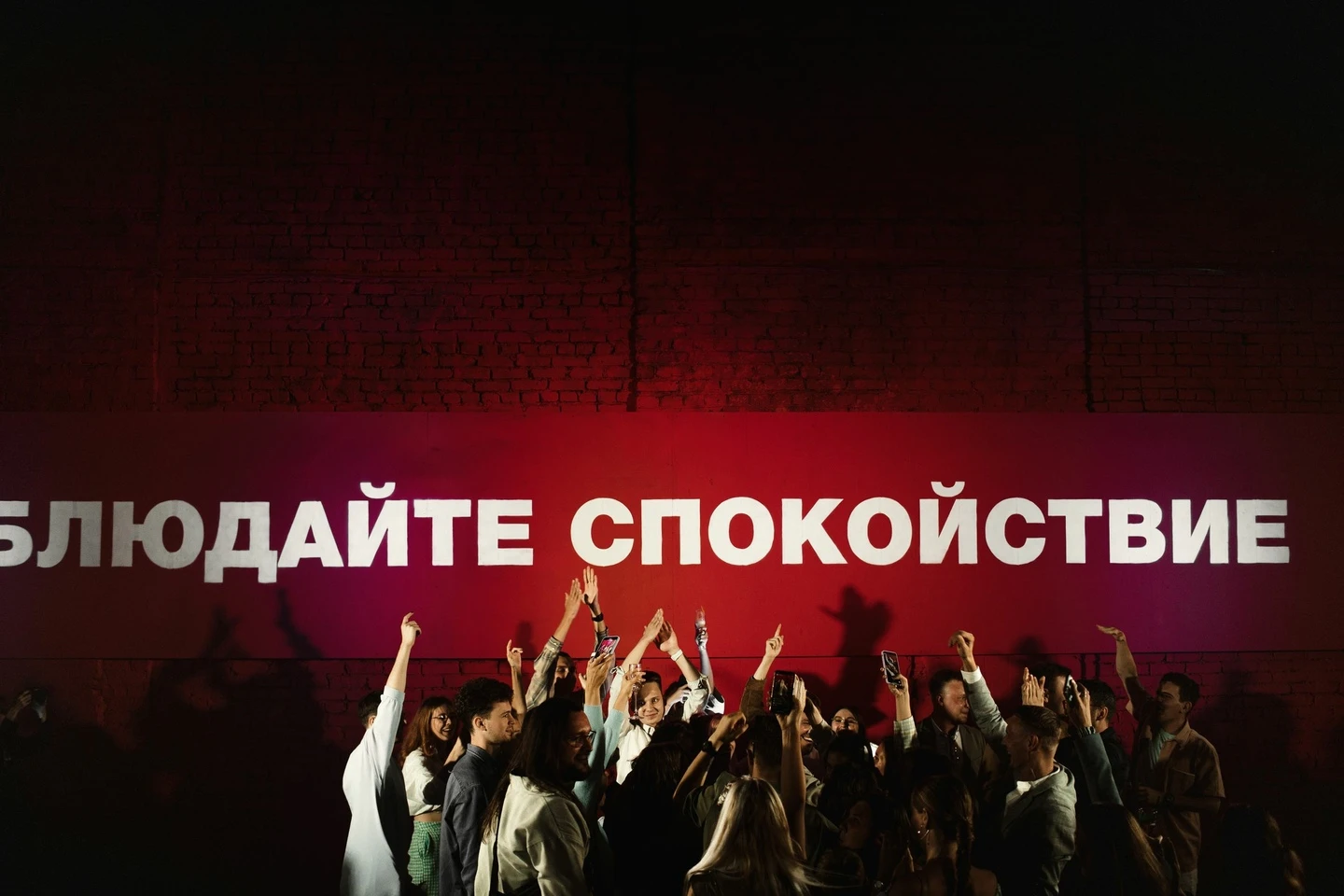 гости танцуют перед проекцией с текстом в красном свете