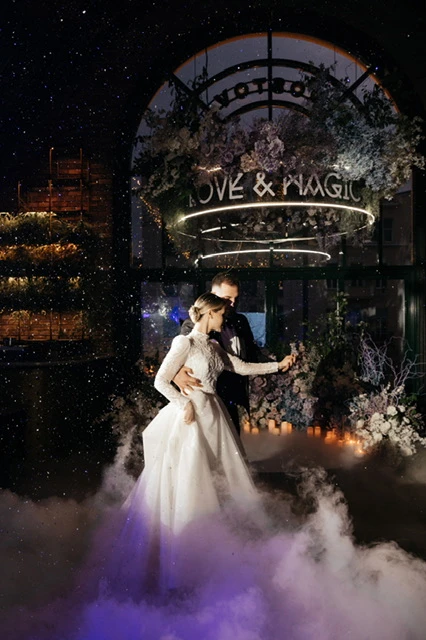 пара танцует в дыму на фоне светящейся вывески love magic
