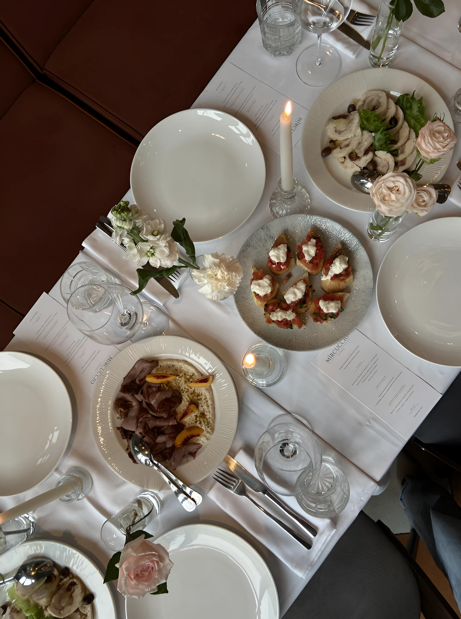 тарелки с брускеттой и мясной нарезкой на праздничном столе